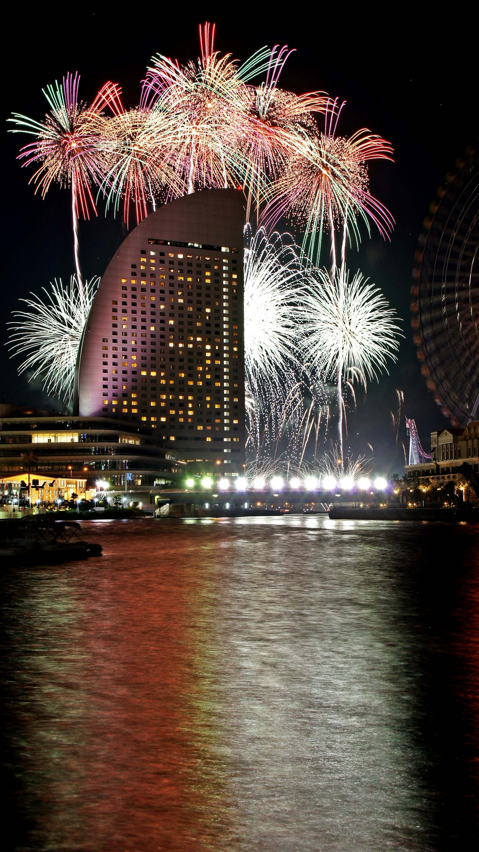Espectáculo de fuegos artificiales coloridos sobre la Torre Landmark de Yokohama por la noche