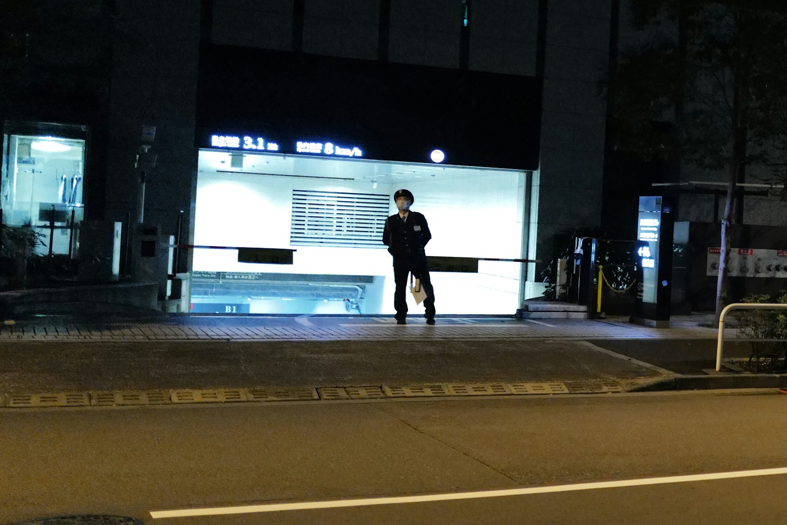 一个人在夜晚明亮的车站标志前站着