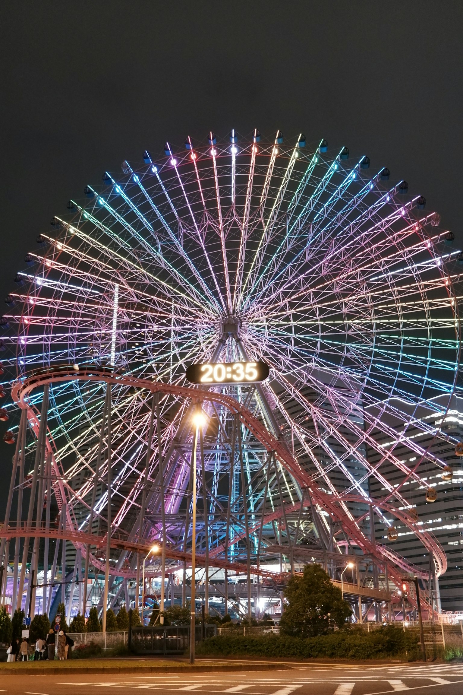 Luci LED colorate illuminano una grande ruota panoramica di notte