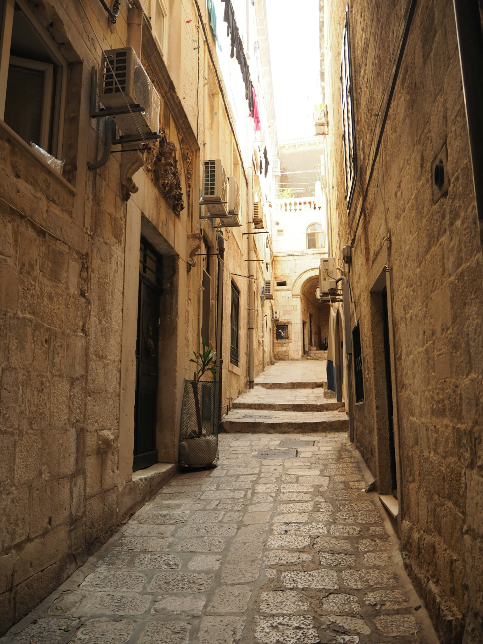 Narrow stone alleyway lined with old buildings