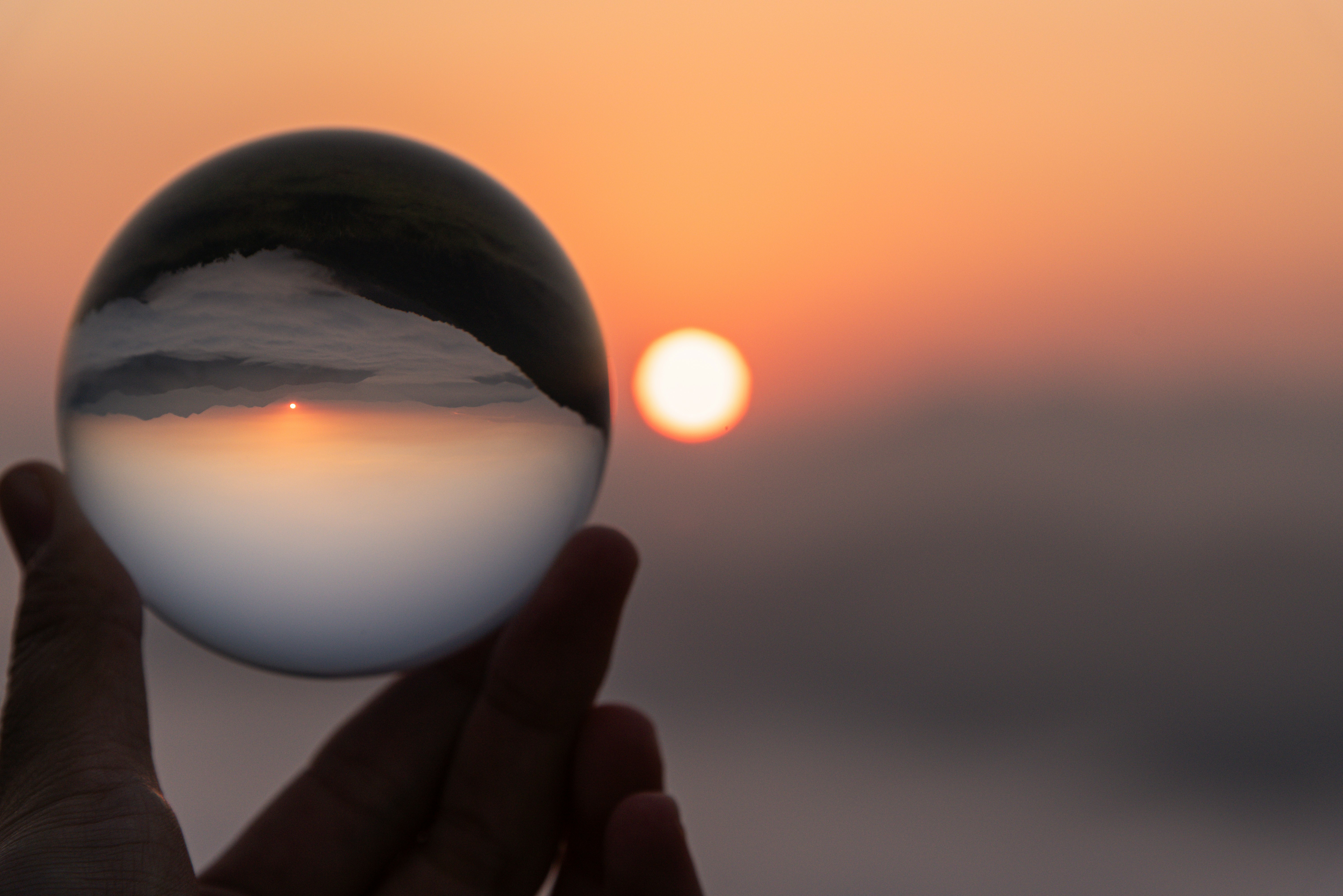 lens ball reflecting a sunset in a hand