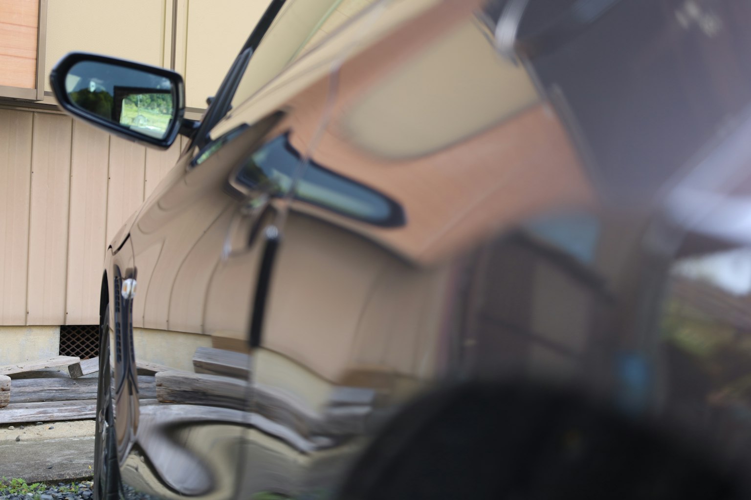 Gros plan sur le côté d'une voiture noire avec des reflets et un miroir