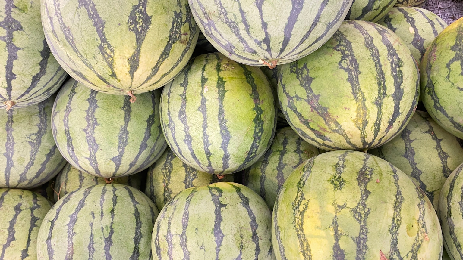 Ein Haufen Wassermelonen mit grün gestreifter Schale