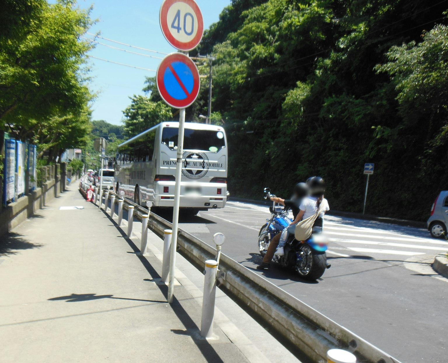 Scene of a bus and motorcycle along a sidewalk by the road