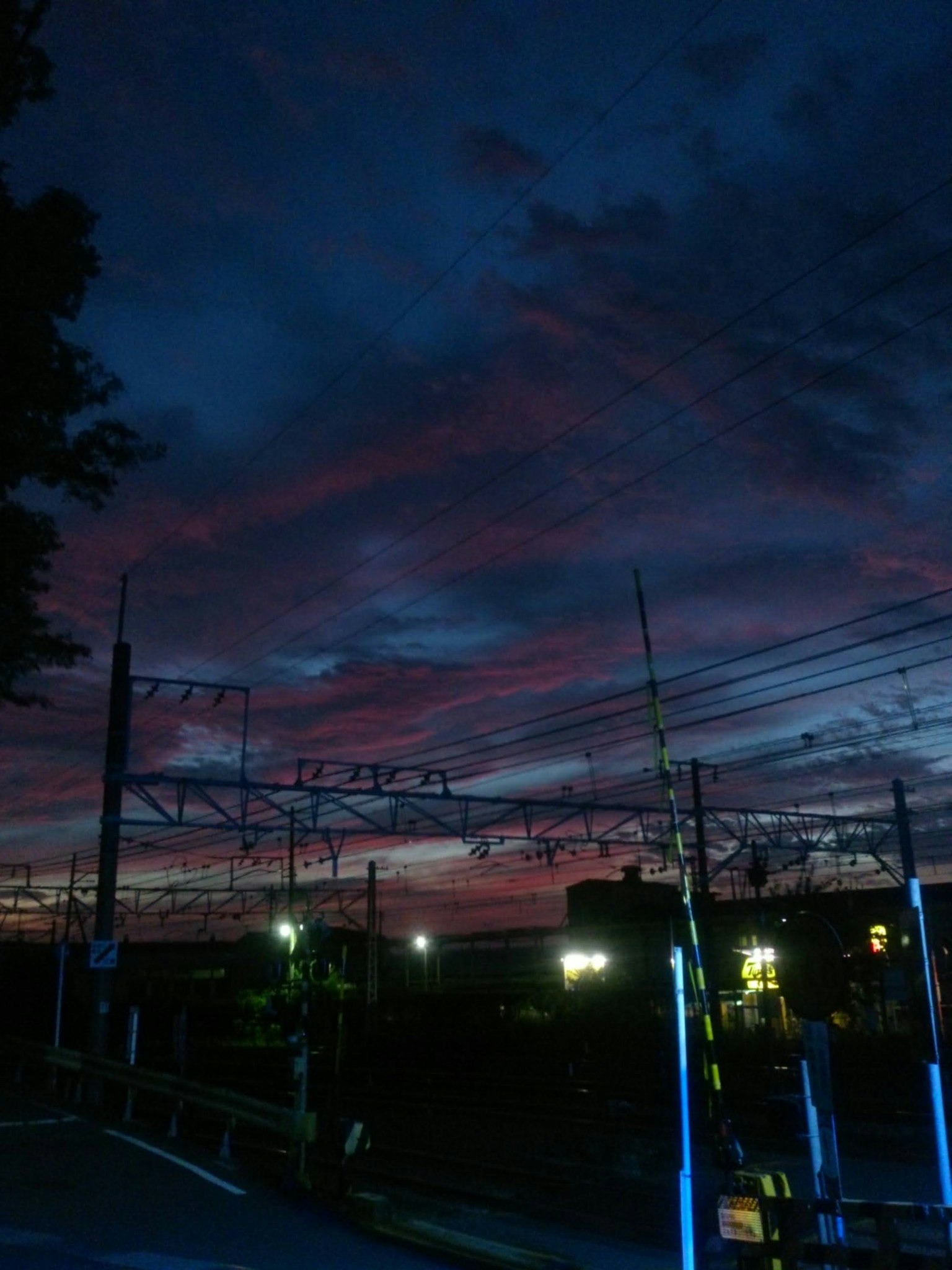 Silhouette der Oberleitungsleitungen der Eisenbahn vor einem Sonnenuntergangshimmel