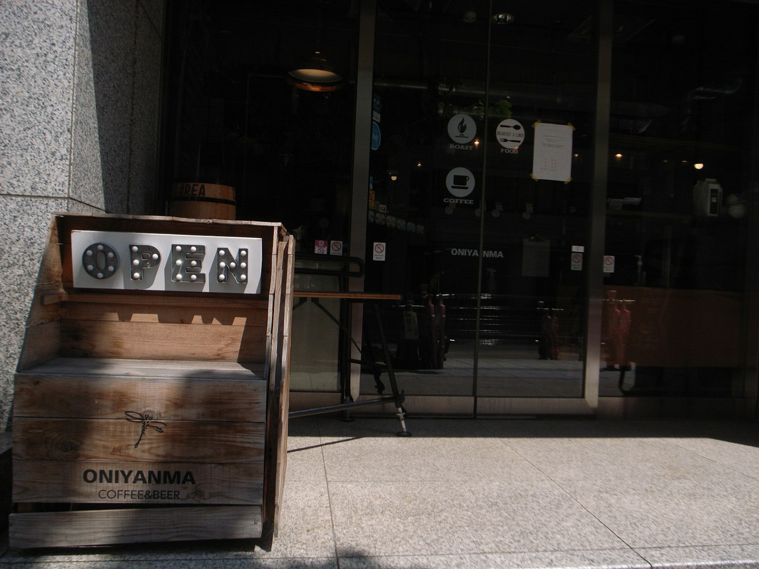 Cafe entrance with a wooden sign and glass doors