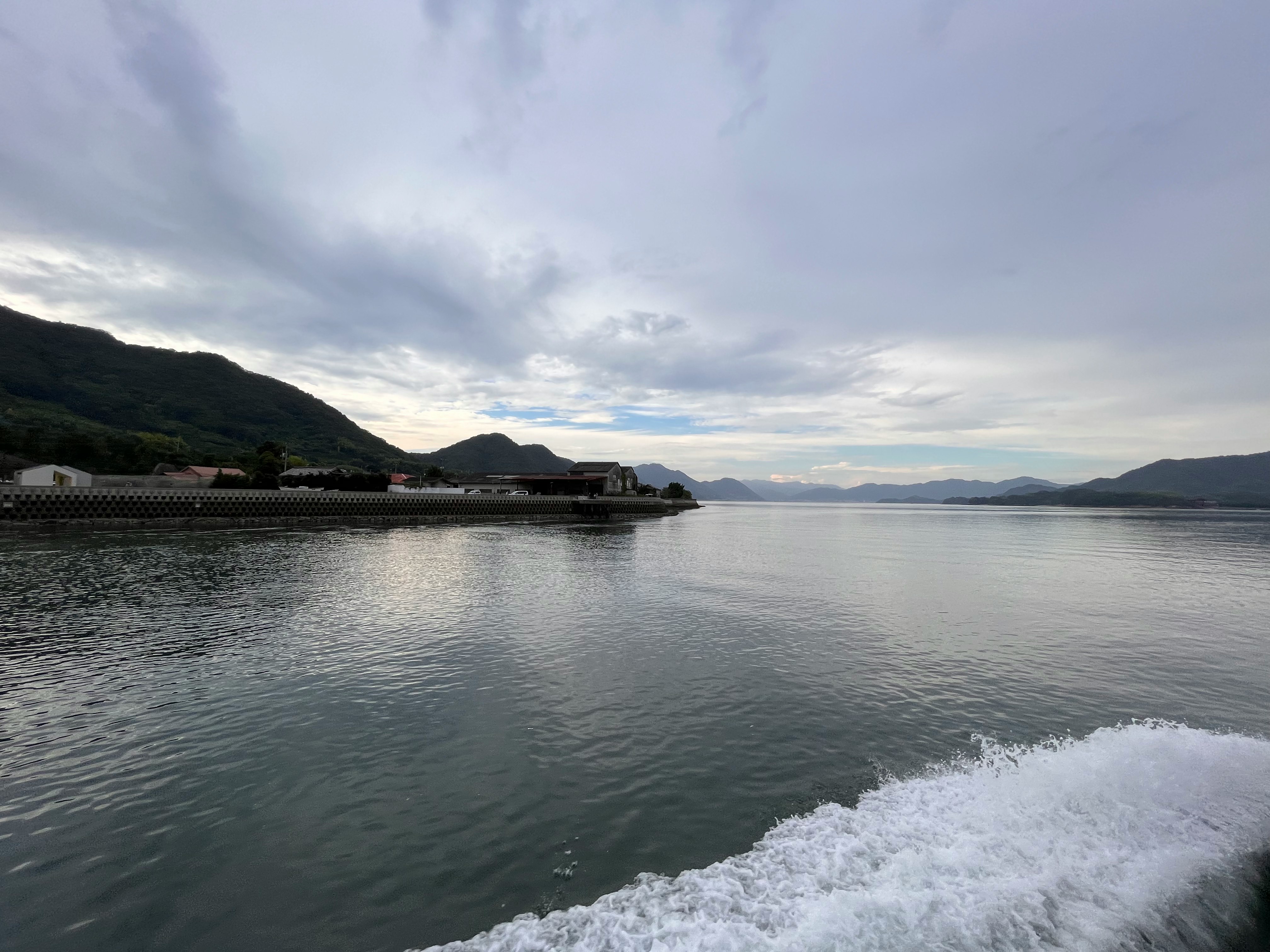 穏やかな海面と遠くの山並みが広がる湾岸の景色