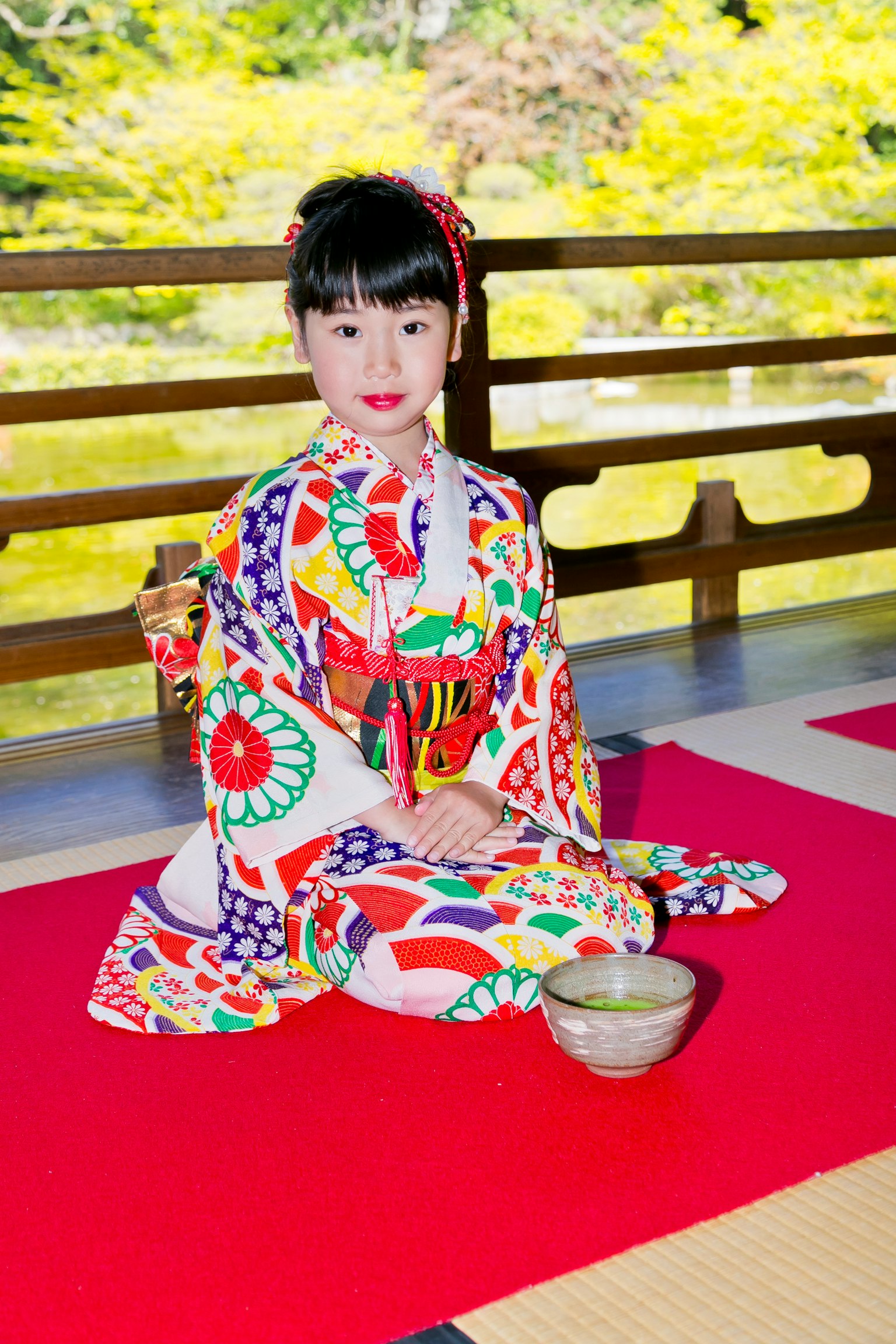 Une fille en kimono coloré assise dans un jardin japonais