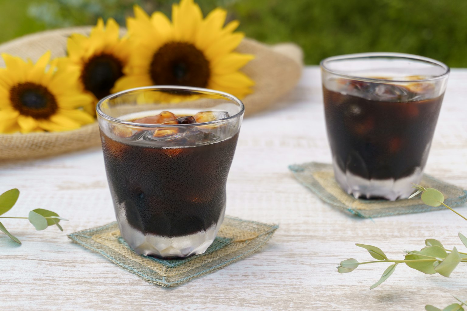 Iced coffee in glasses with sunflowers in the background