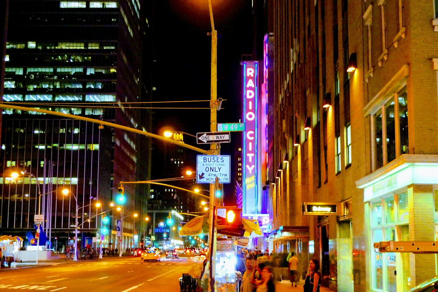 Vue nocturne du Radio City Music Hall avec les gratte-ciels environnants