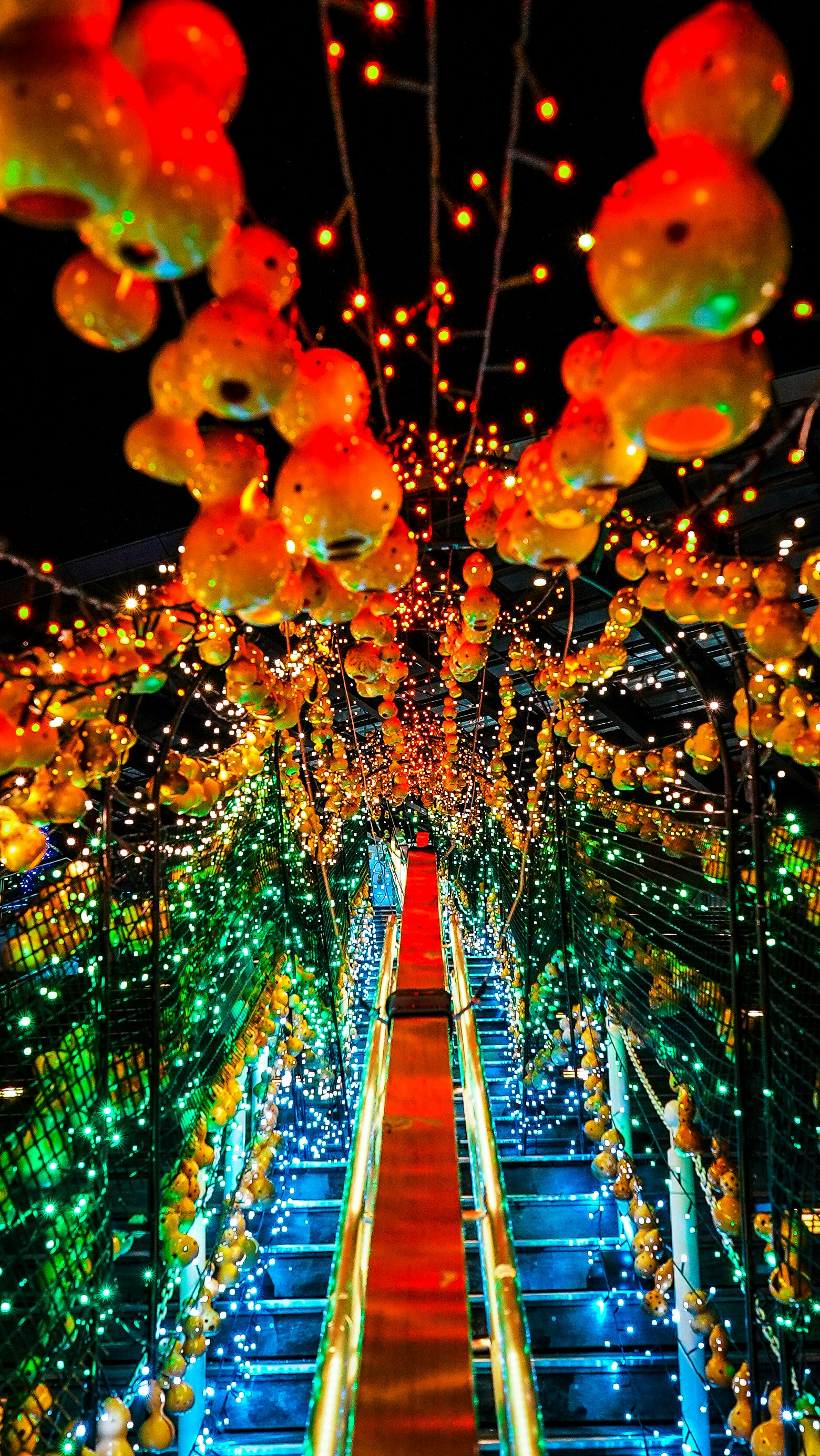 Bild einer Treppe wie ein Lichttunnel mit bunten Lichterketten