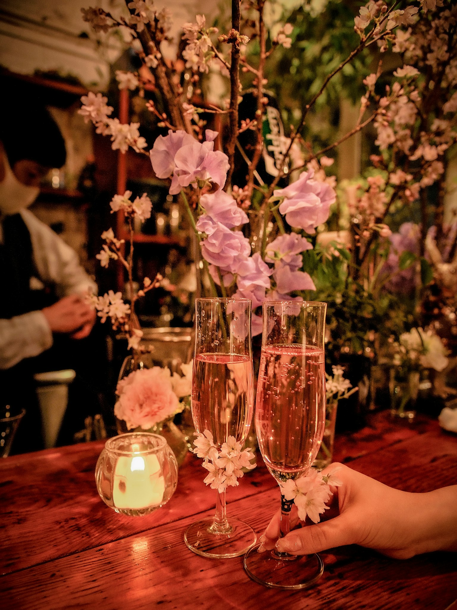 아름답게 꾸며진 테이블 위에 꽃으로 장식된 샴페인 잔 두 개
