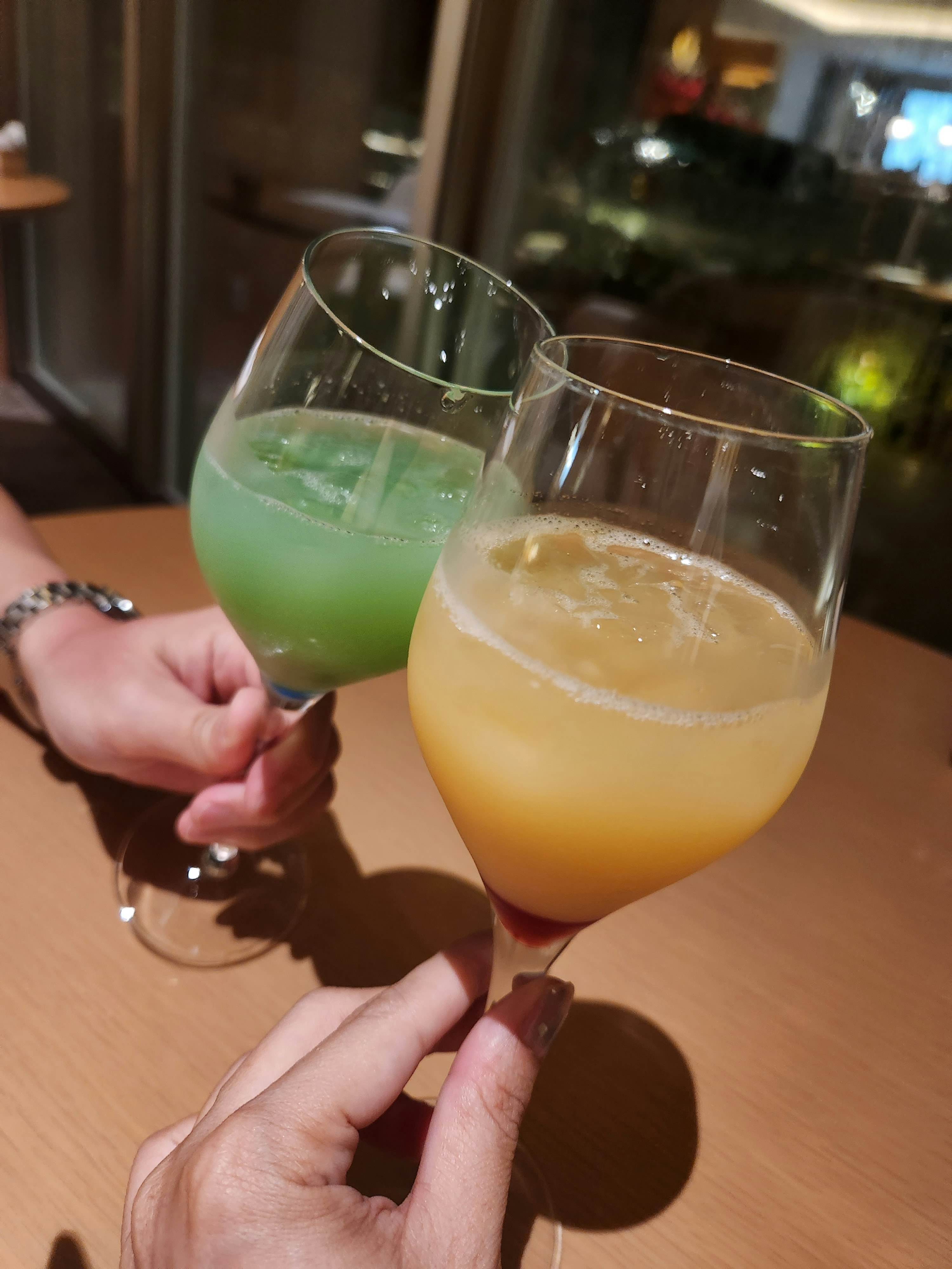 Couple clinking cocktail glasses at a table