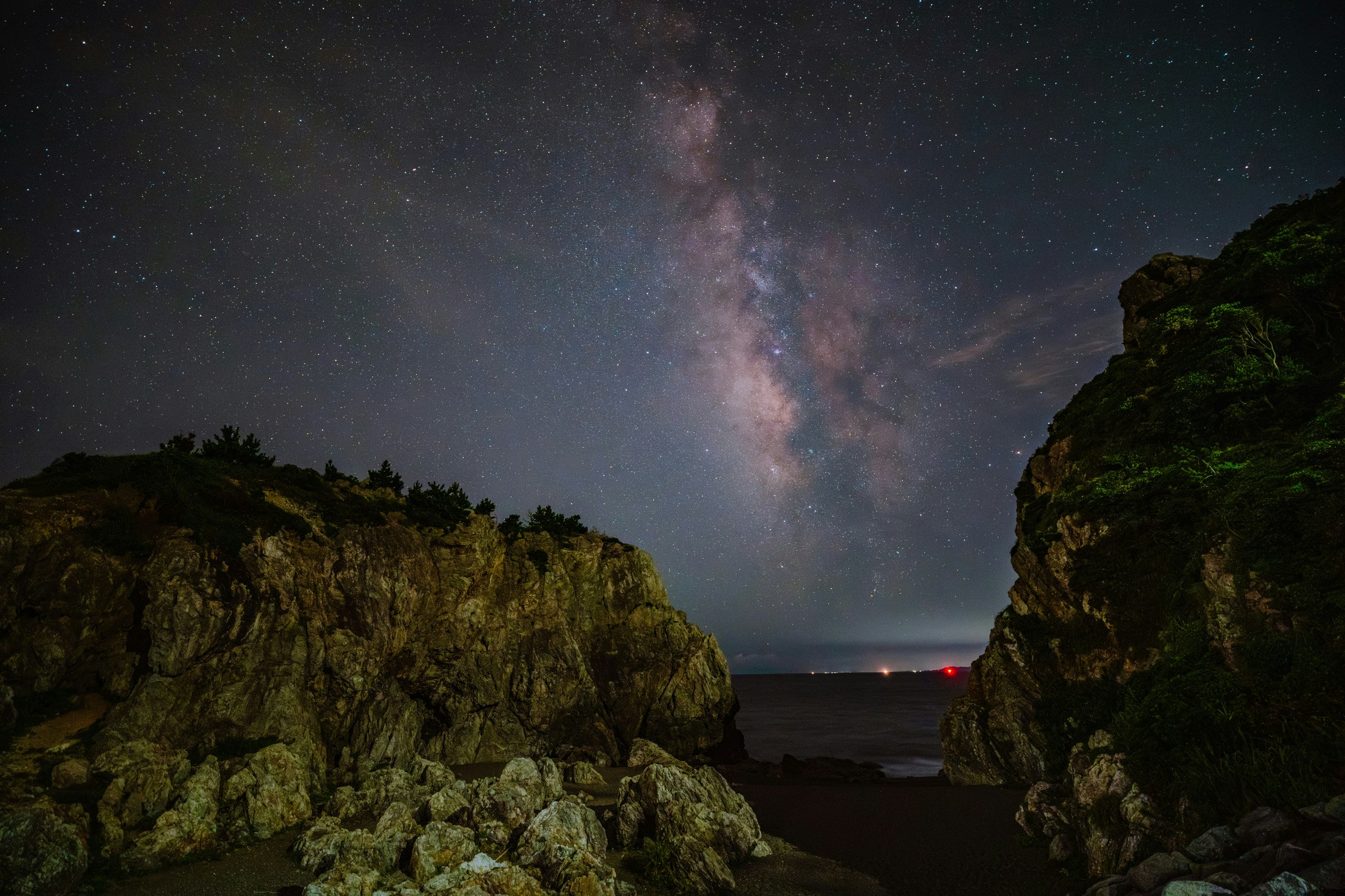 岩場の間に広がる天の川の星空