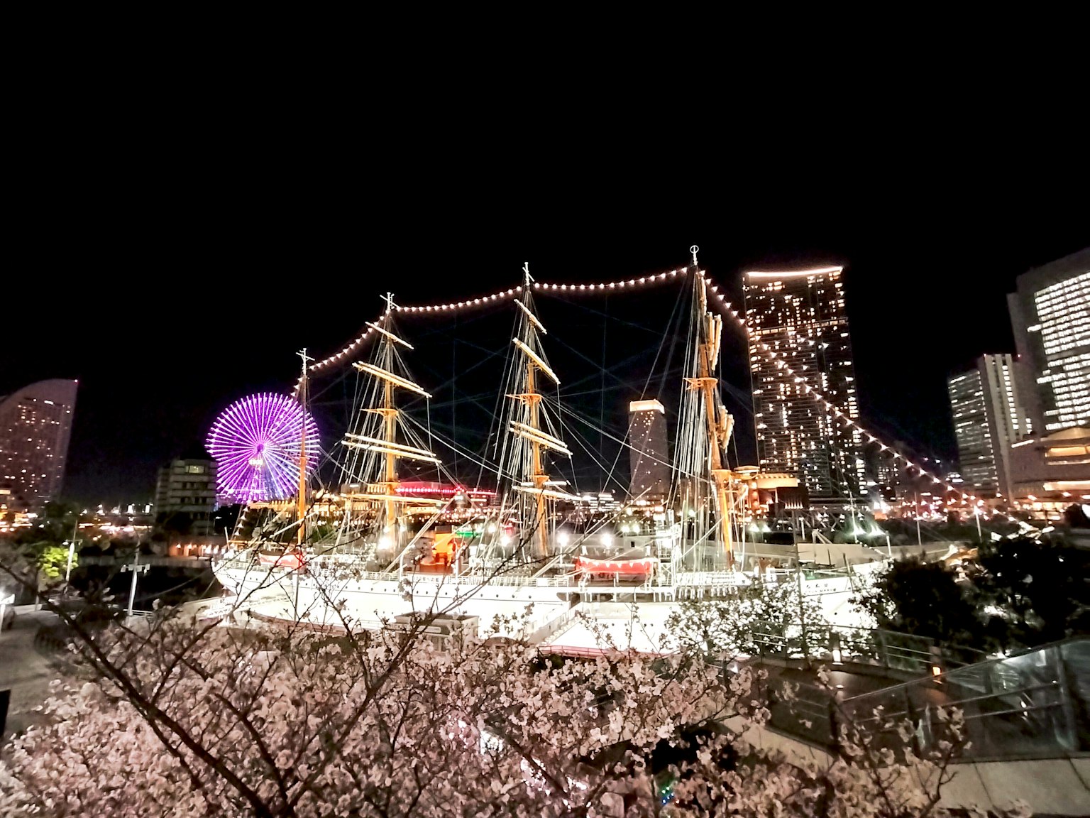 Kapal yang diterangi dengan bunga sakura di malam hari dan cakrawala kota