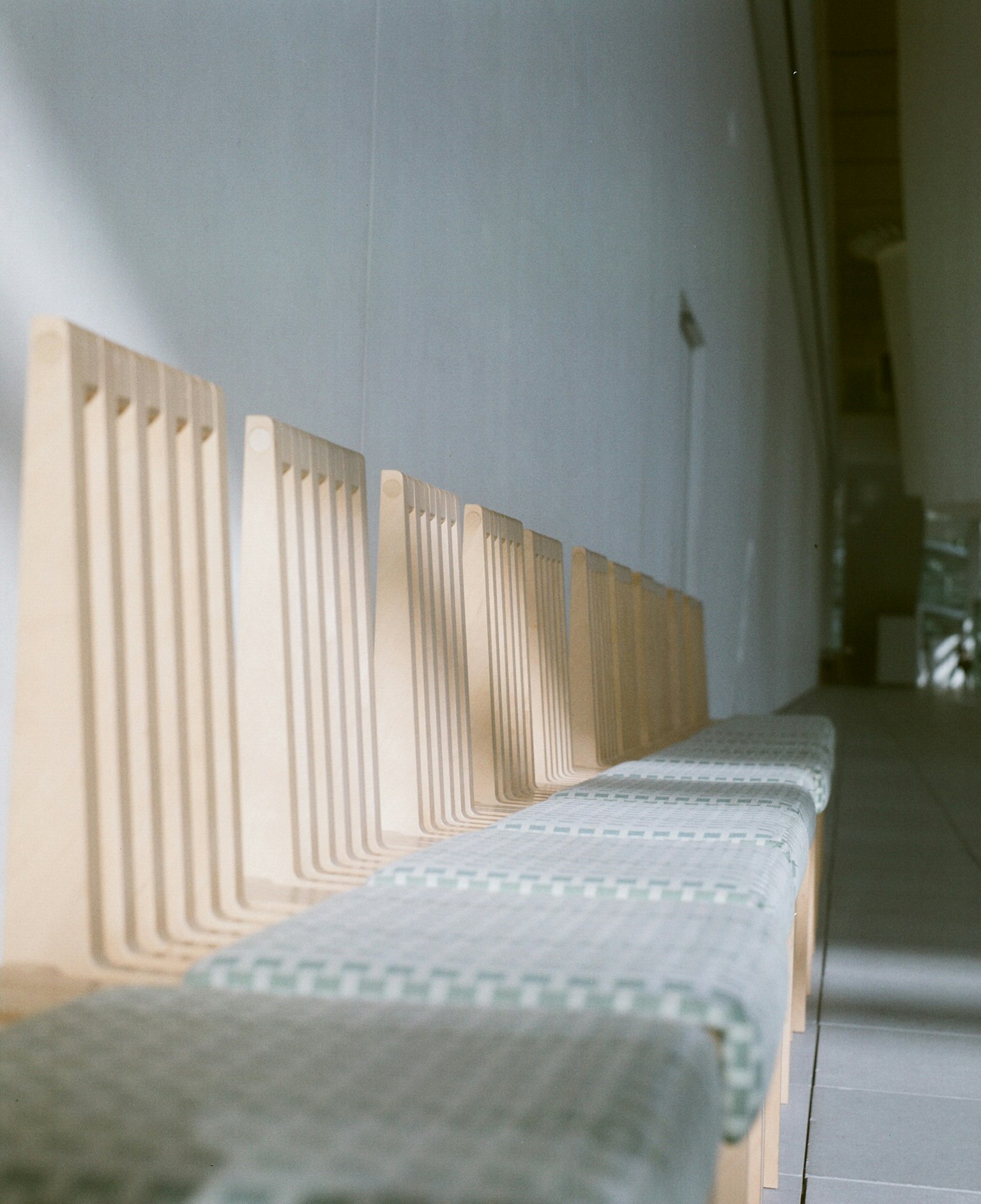 Une rangée de chaises en bois dans un espace intérieur moderne