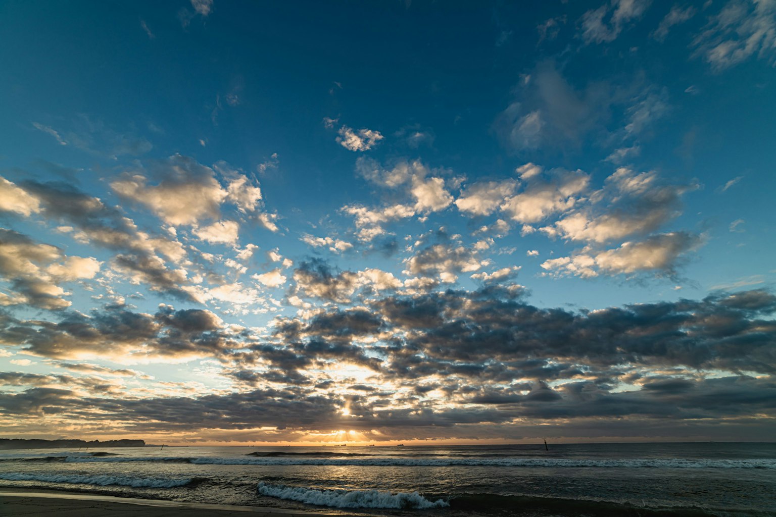 Coastal sunset sky with scattered clouds and blue hues