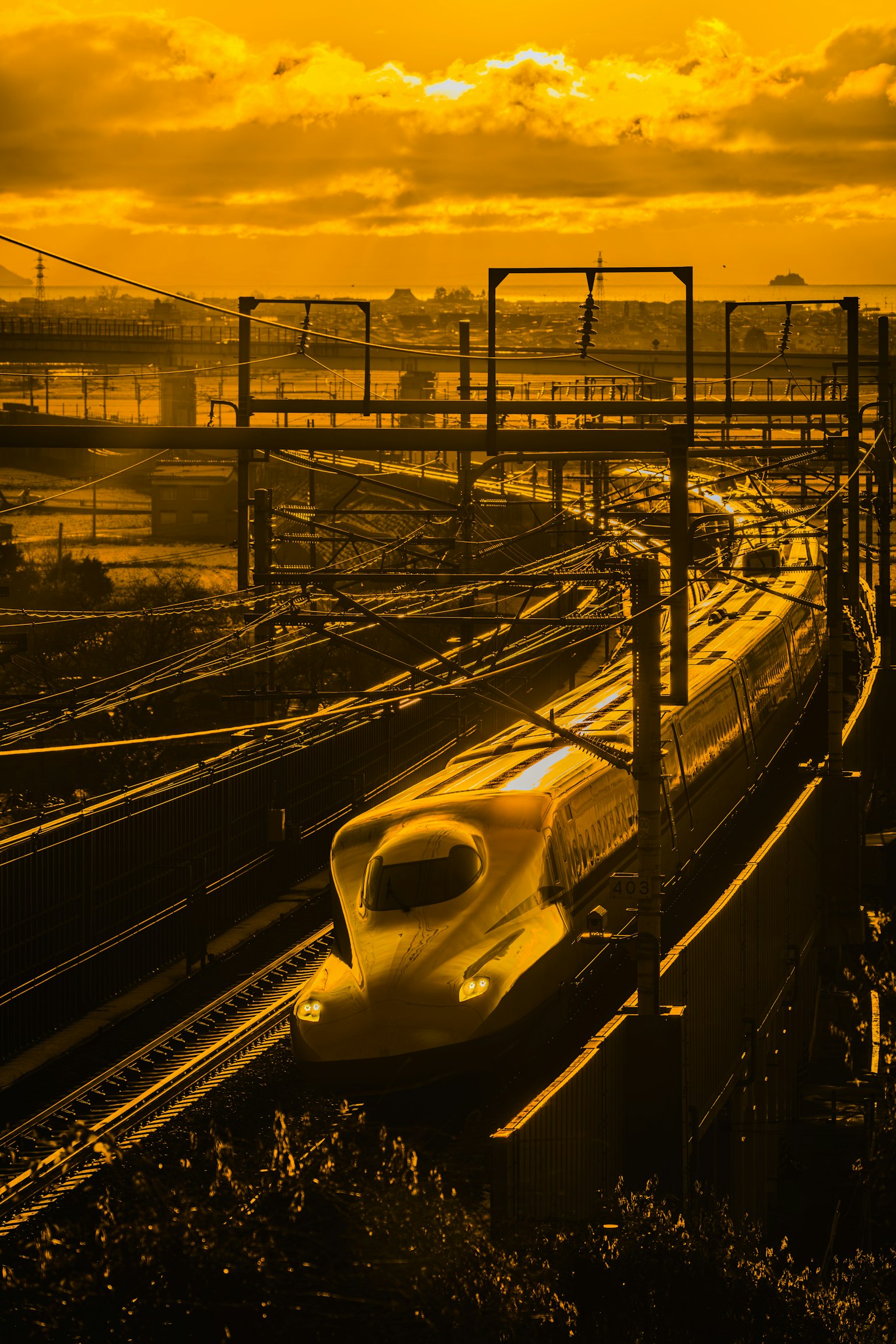 Shinkansen che corre attraverso un tramonto dai colori arancioni vivaci