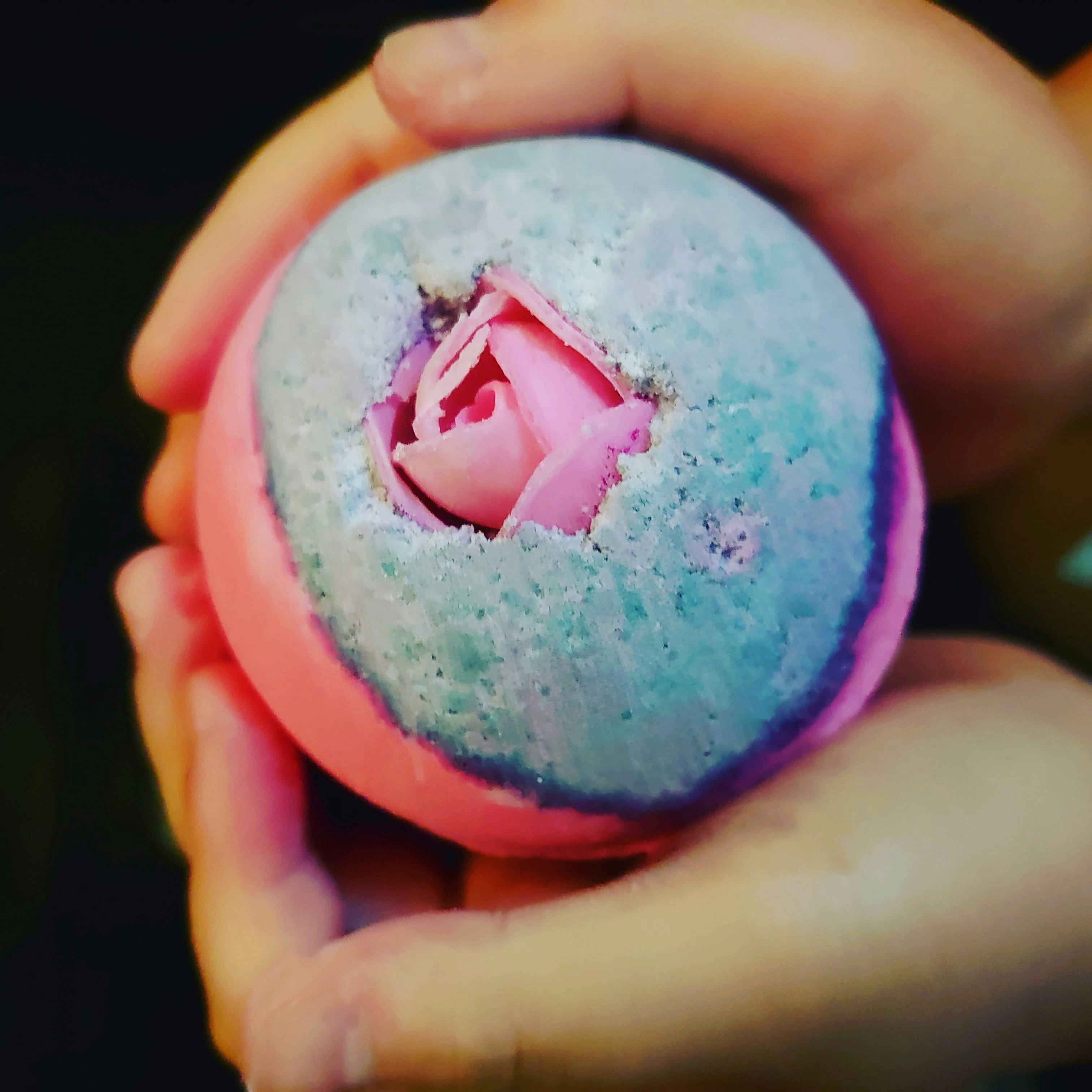 手里捧着的蓝色沐浴球里露出的粉色花瓣