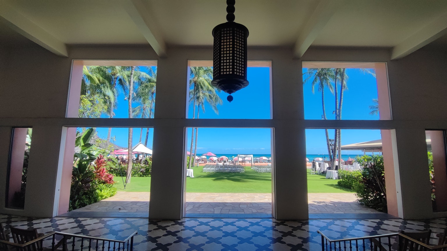 Vista spaziosa della hall con scena di spiaggia caratterizzata da palme e cielo blu