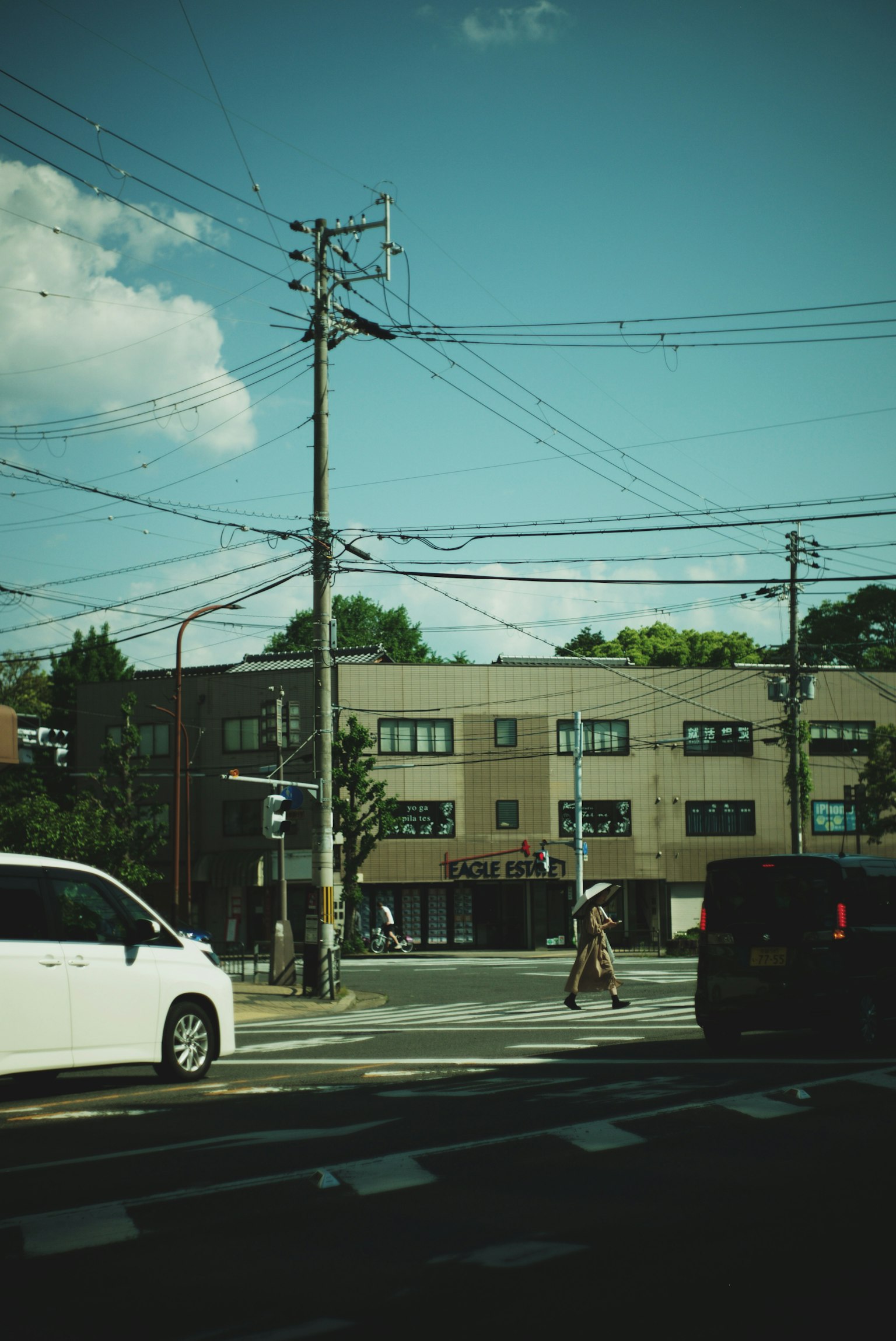 Vista di un angolo di strada con edifici e linee elettriche sotto un cielo blu
