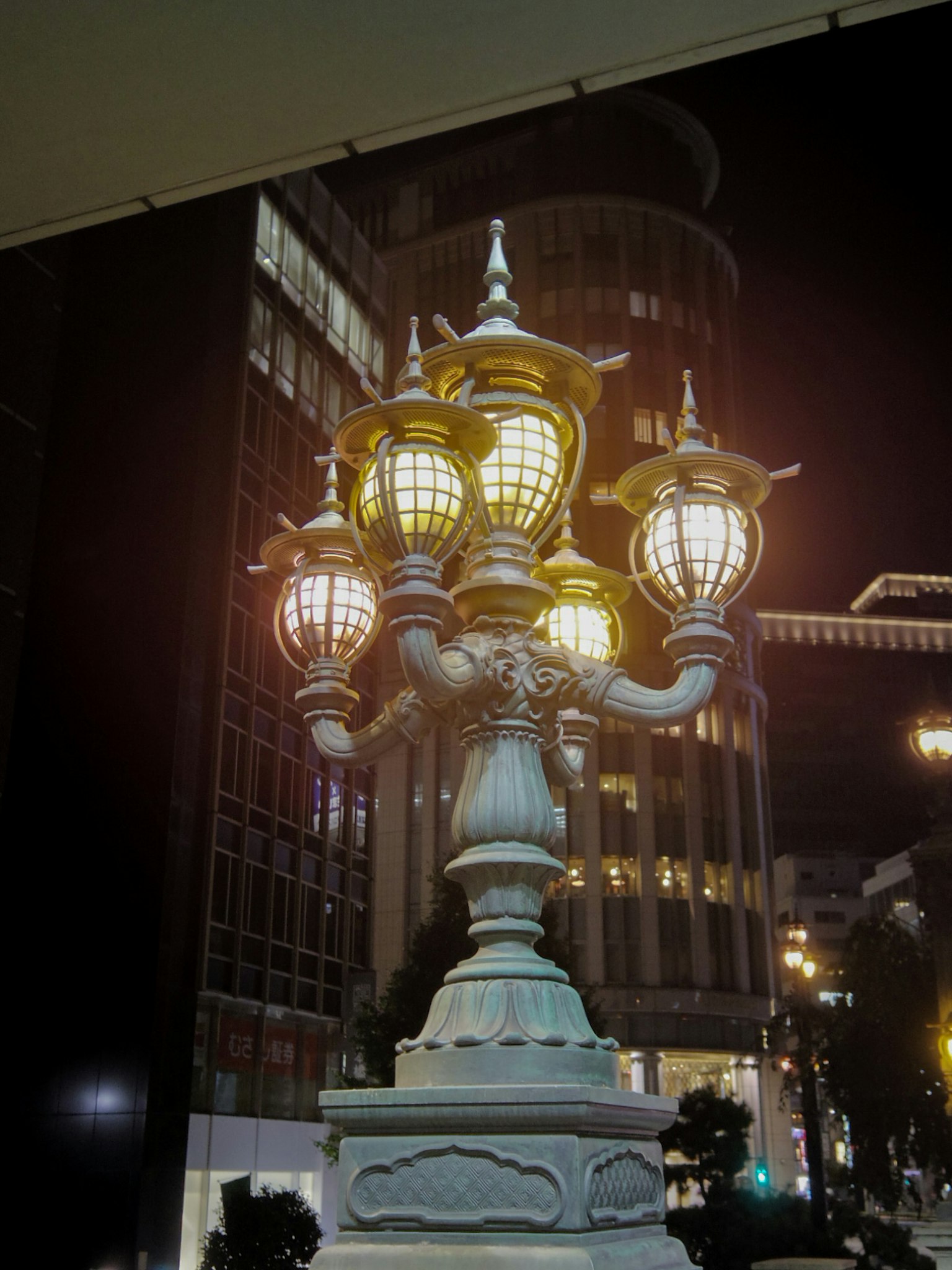 夜间照亮的装饰性街灯位于城市环境中