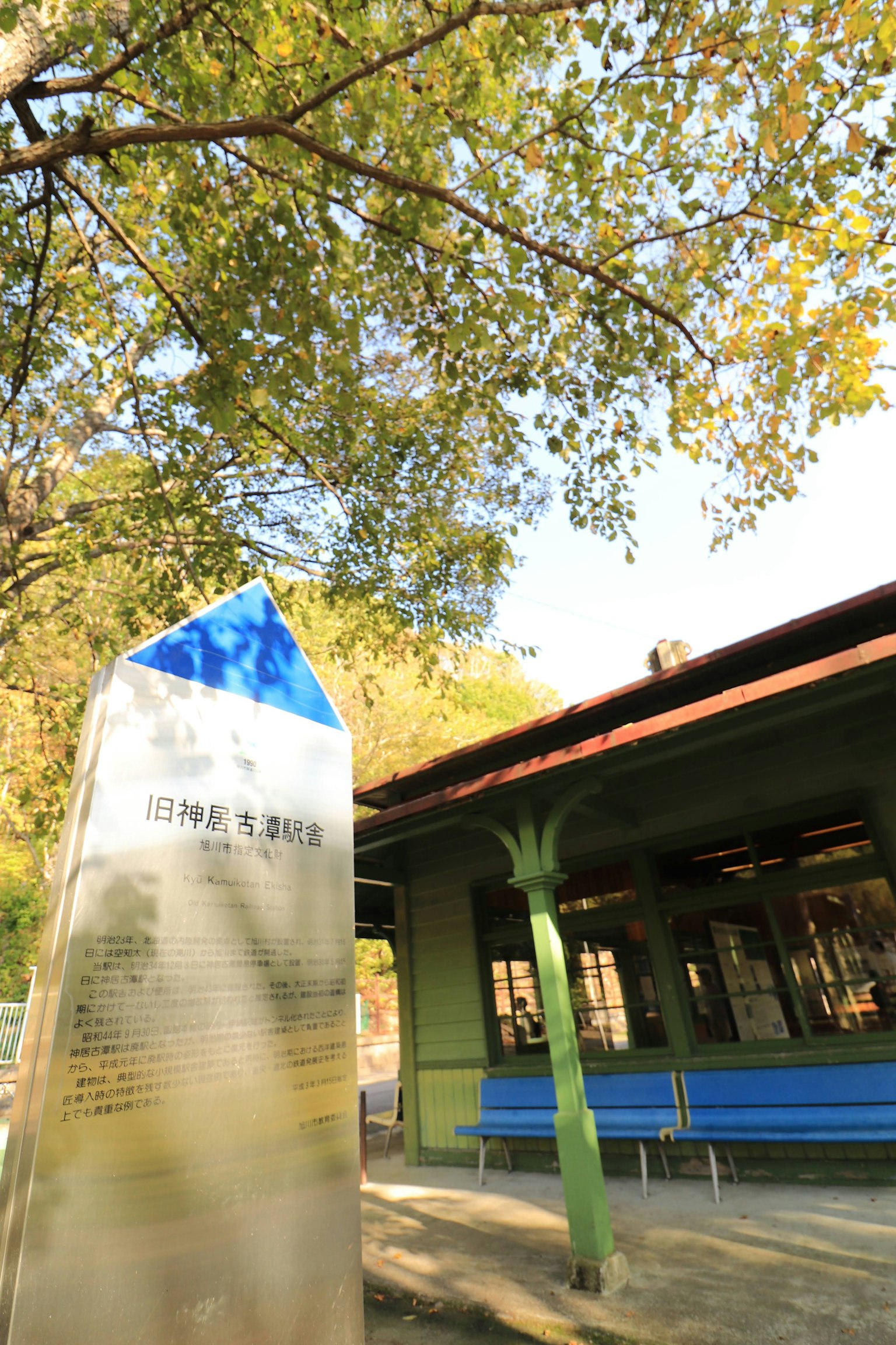 Parkszene mit blauem Dachgebäude und Denkmal