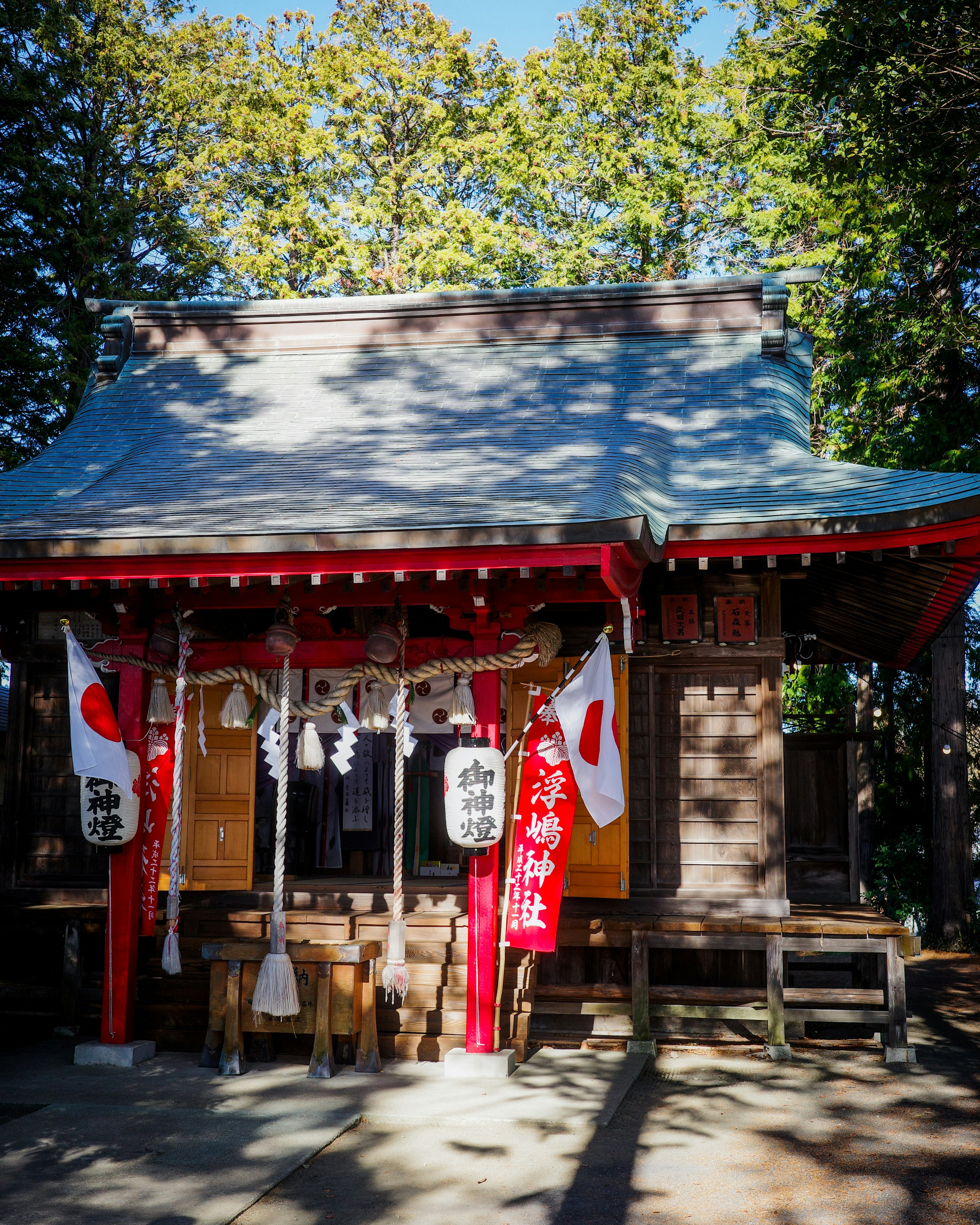 ngôi đền nhỏ với cờ đỏ cạnh cổng torii