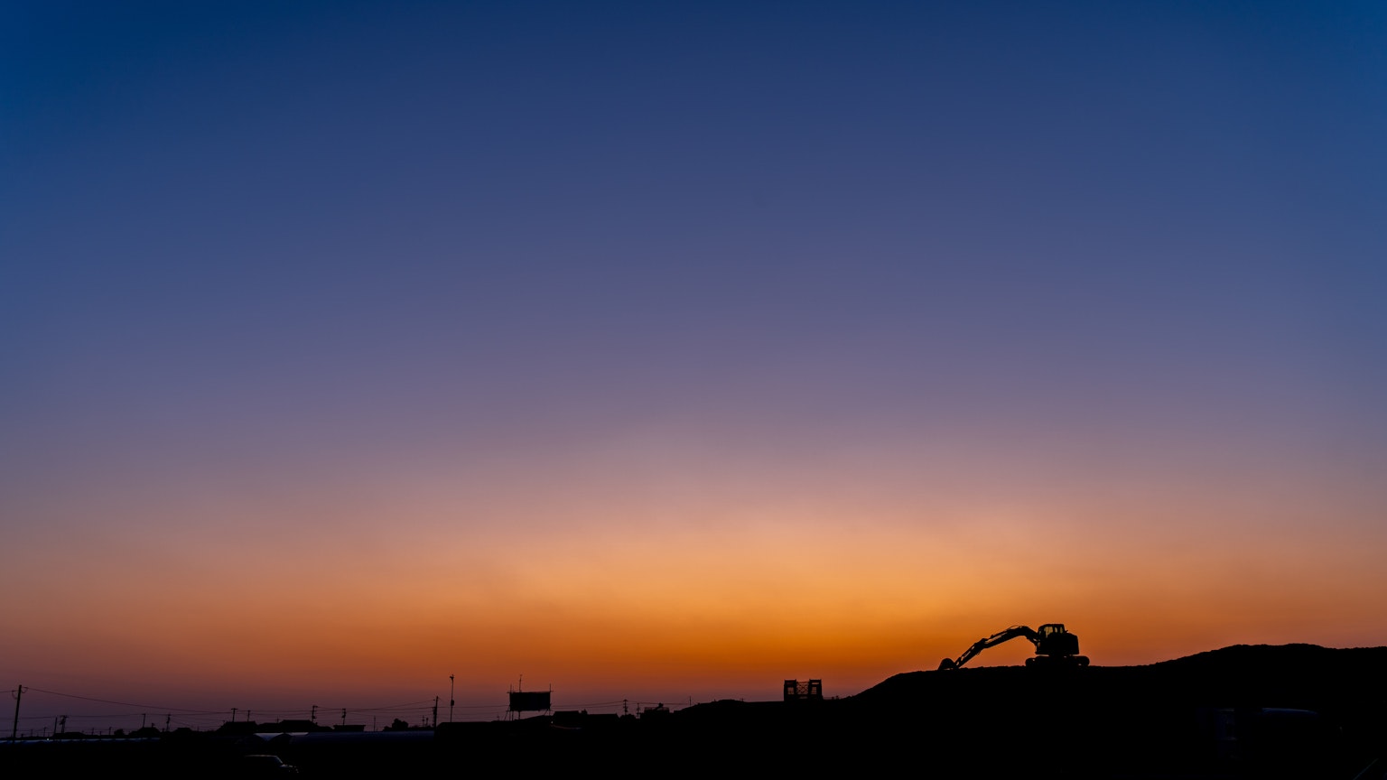 Stunning sunset sky with silhouettes of buildings and machinery
