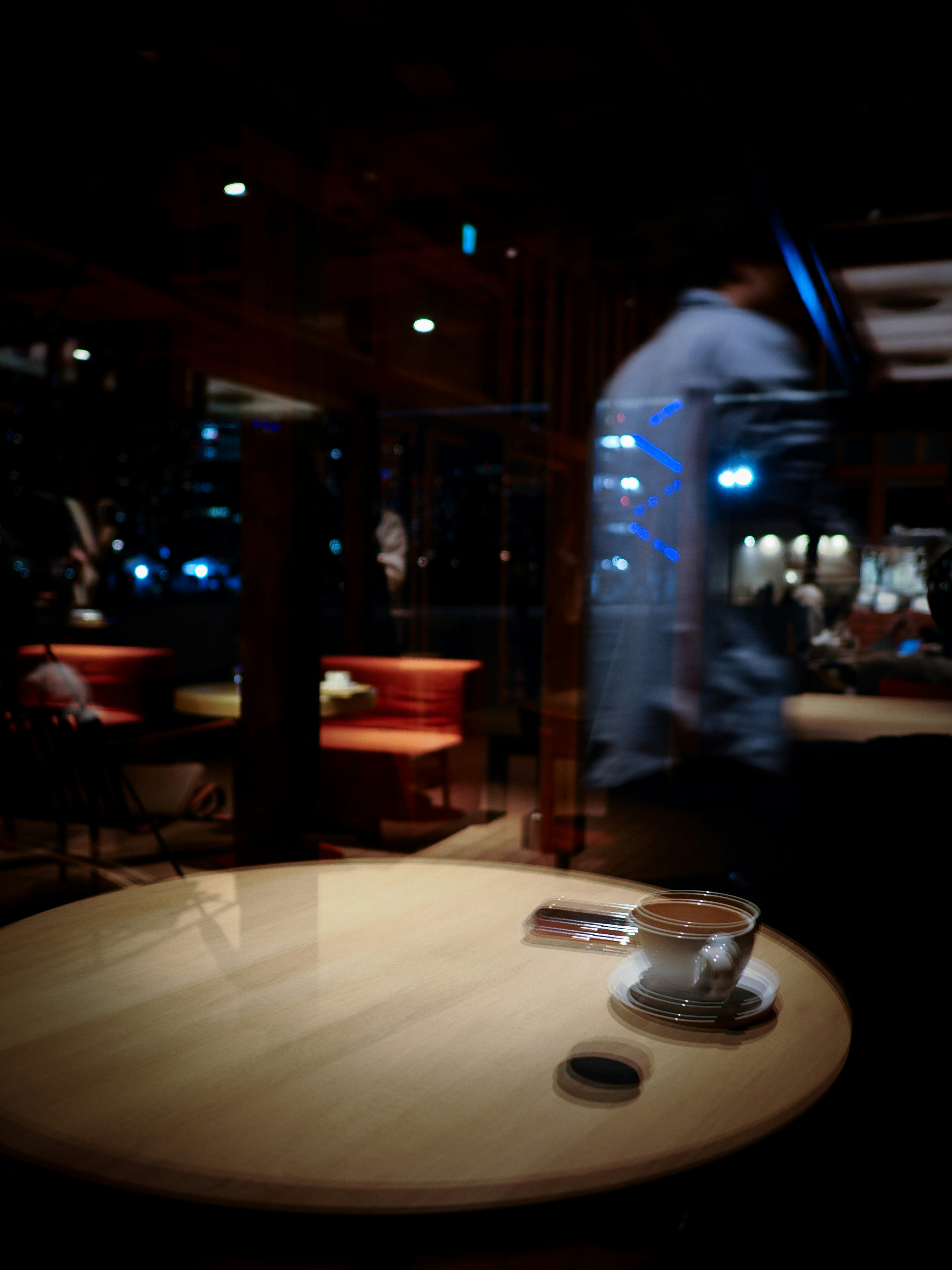 カフェ店内のガラスに映るタワマンの光と幻想的な反射