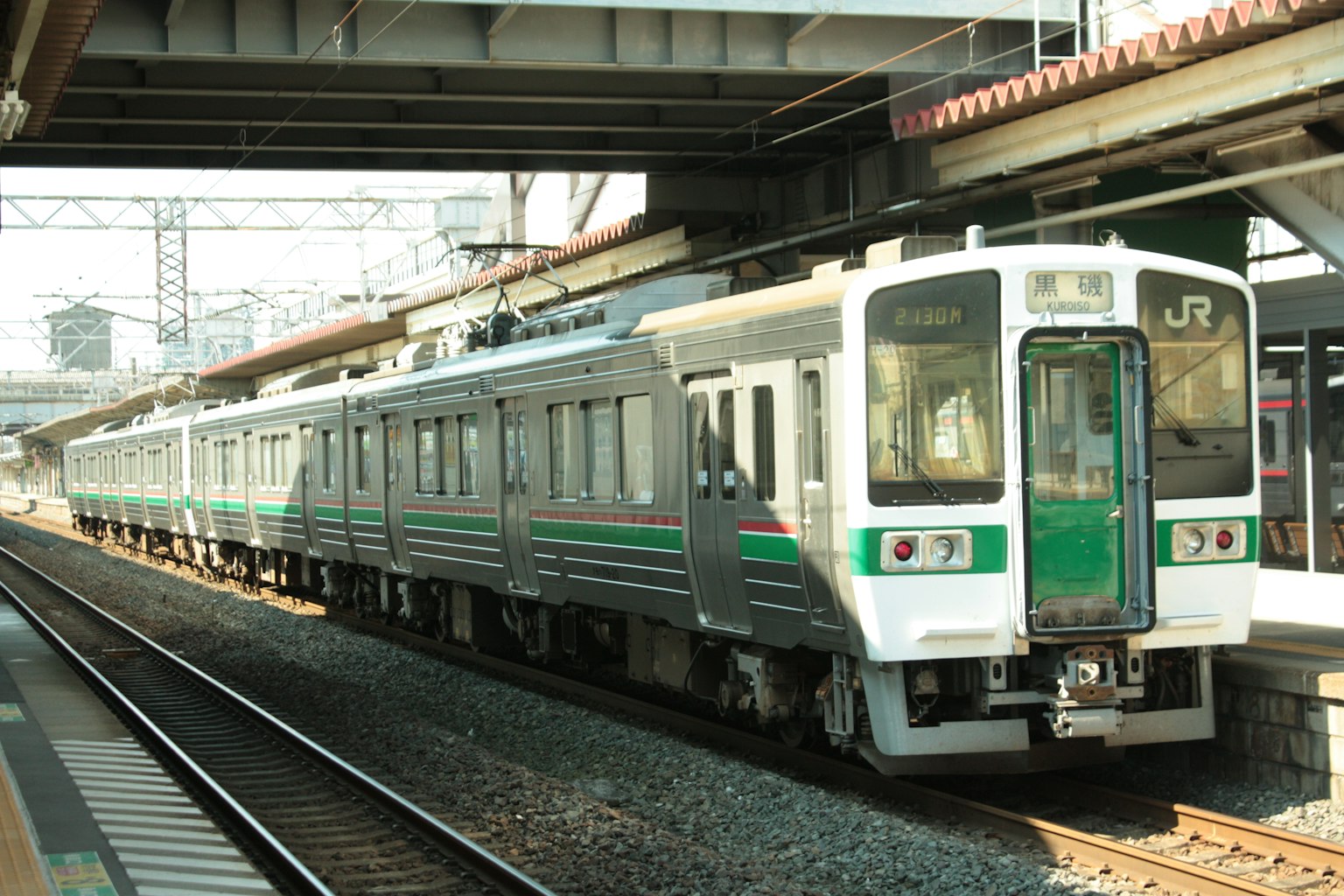 Tren verde y blanco detenido en la estación