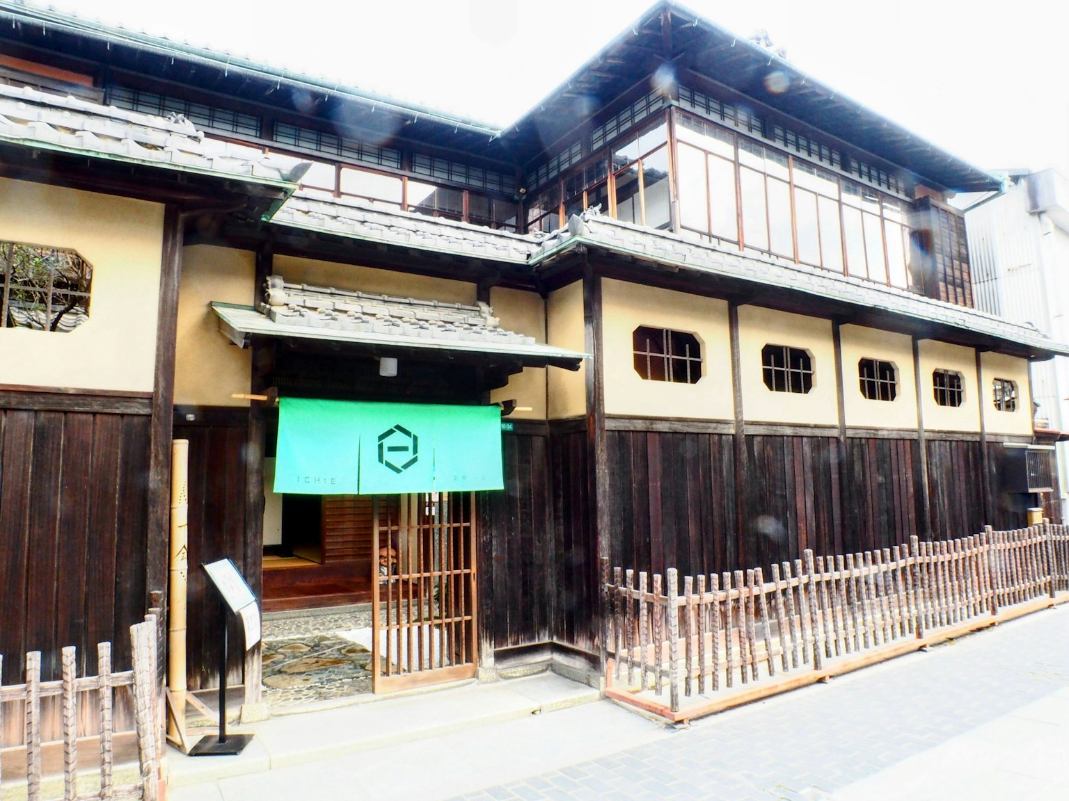 传统日本建筑外观，挂着绿色暖帘