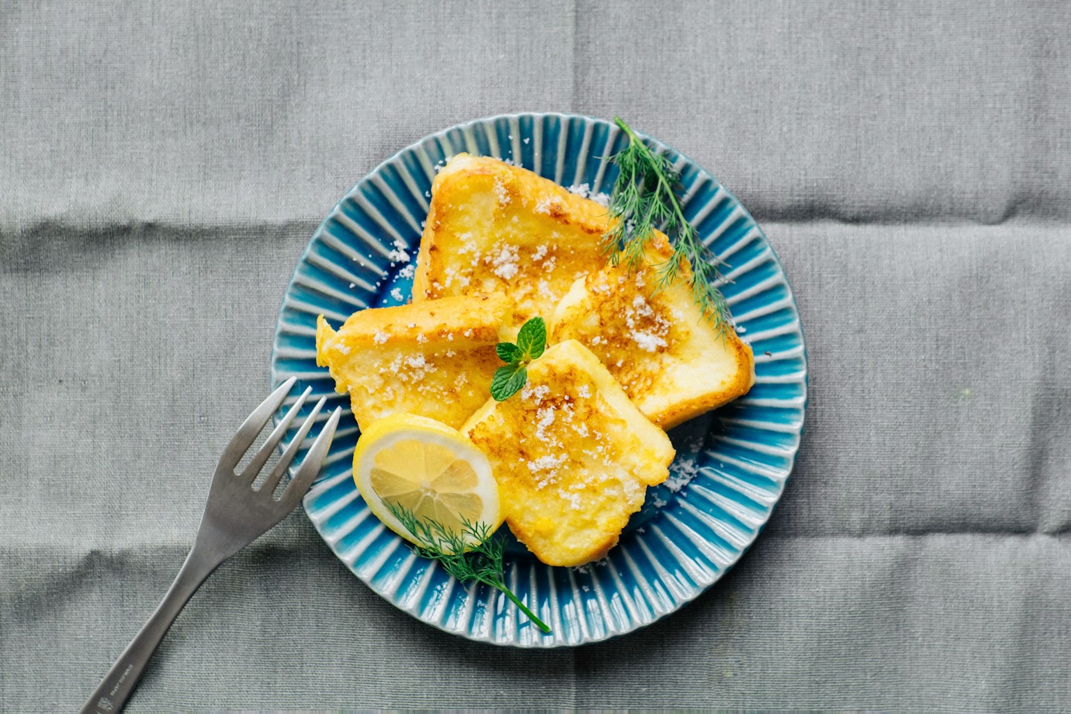 Toast garni de citron et d'herbes sur une assiette bleue