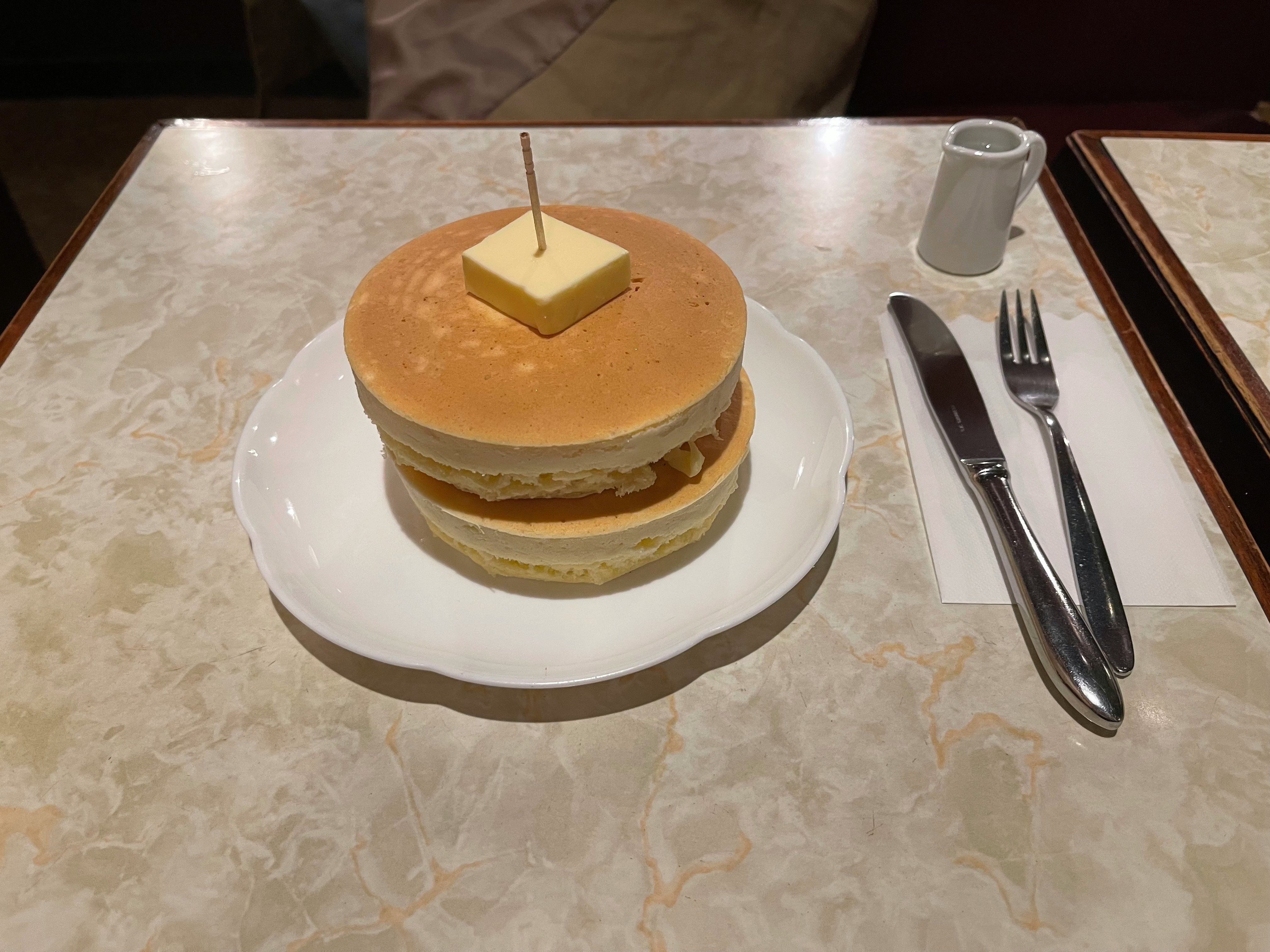 cake on a plate with cutlery on a dining table