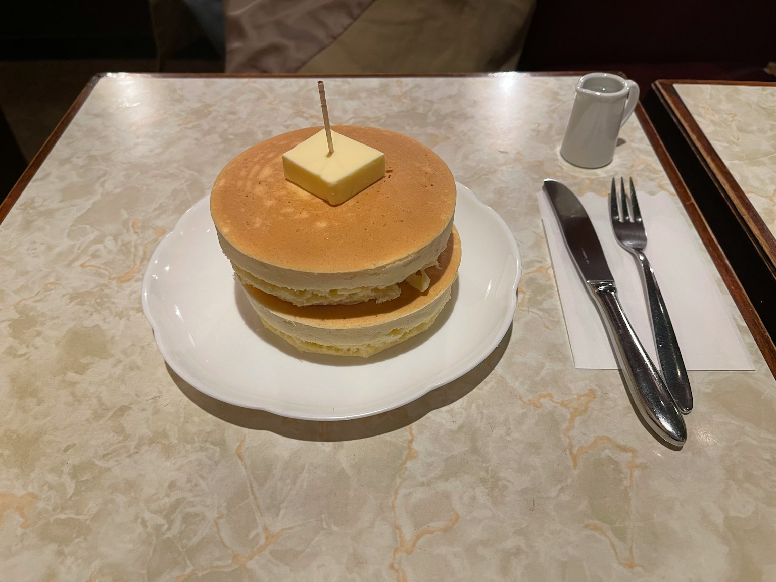 Fluffige Pfannkuchen gestapelt mit einer Scheibe Butter oben