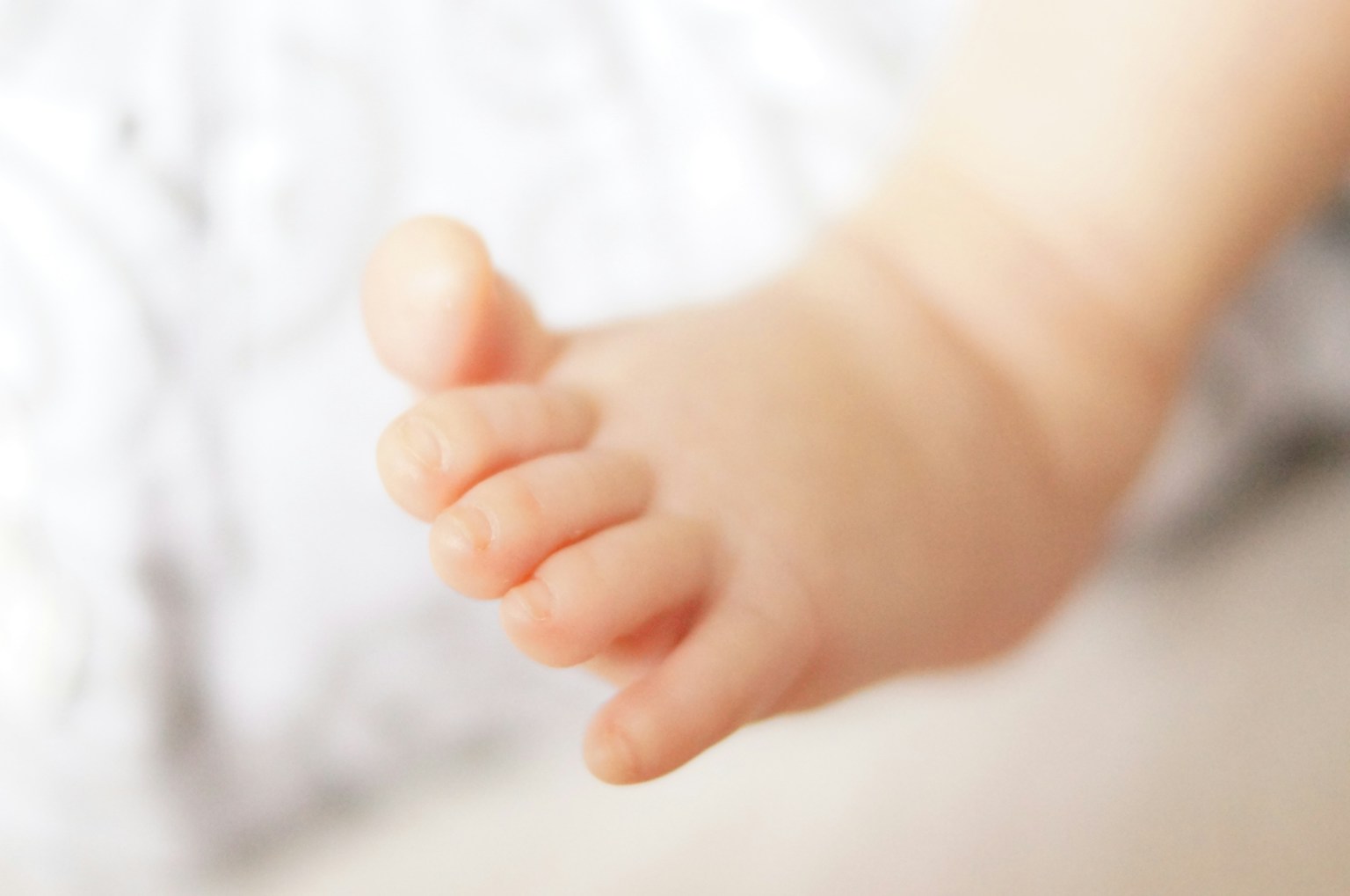 Cận cảnh bàn chân em bé da mềm và ngón chân nhỏ