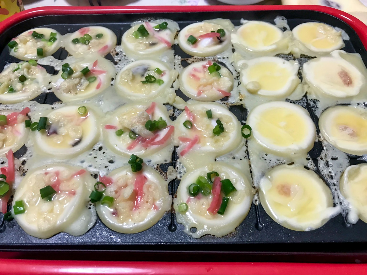 Plats de takoyaki et d'œufs cuisant sur une plaque à takoyaki