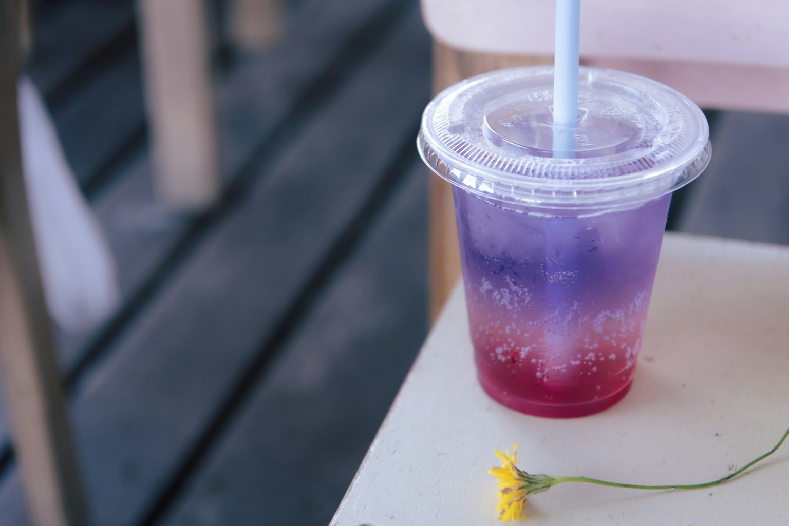 Una bevanda colorata con strati viola e rossi in un bicchiere trasparente