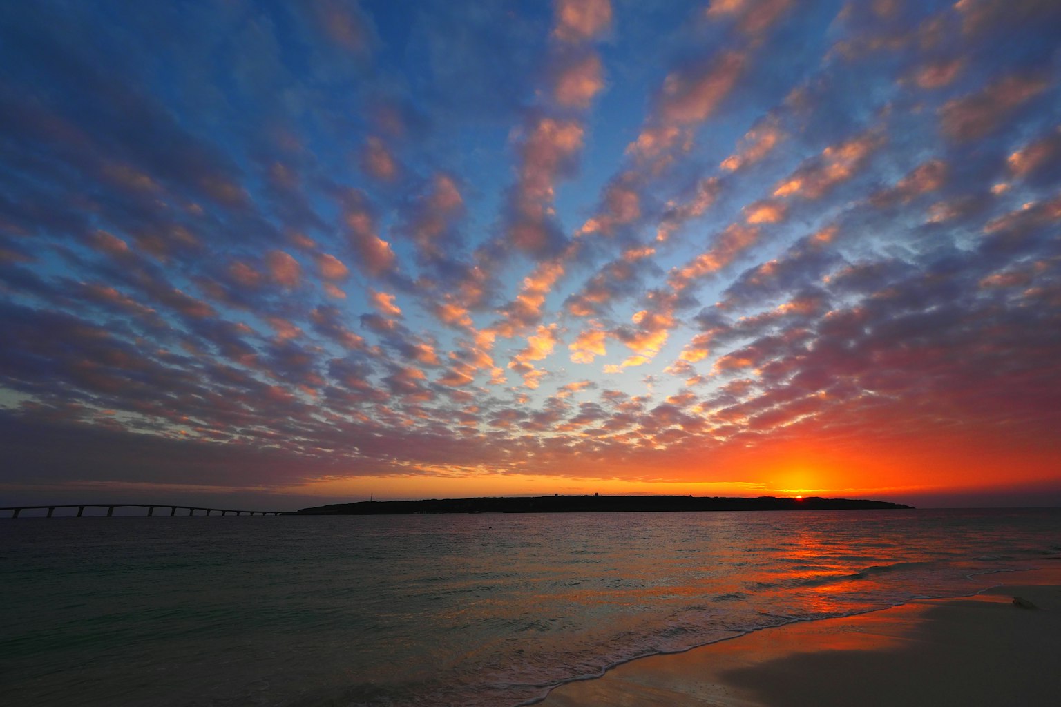 Stunning sunset with colorful clouds over a calm ocean beach