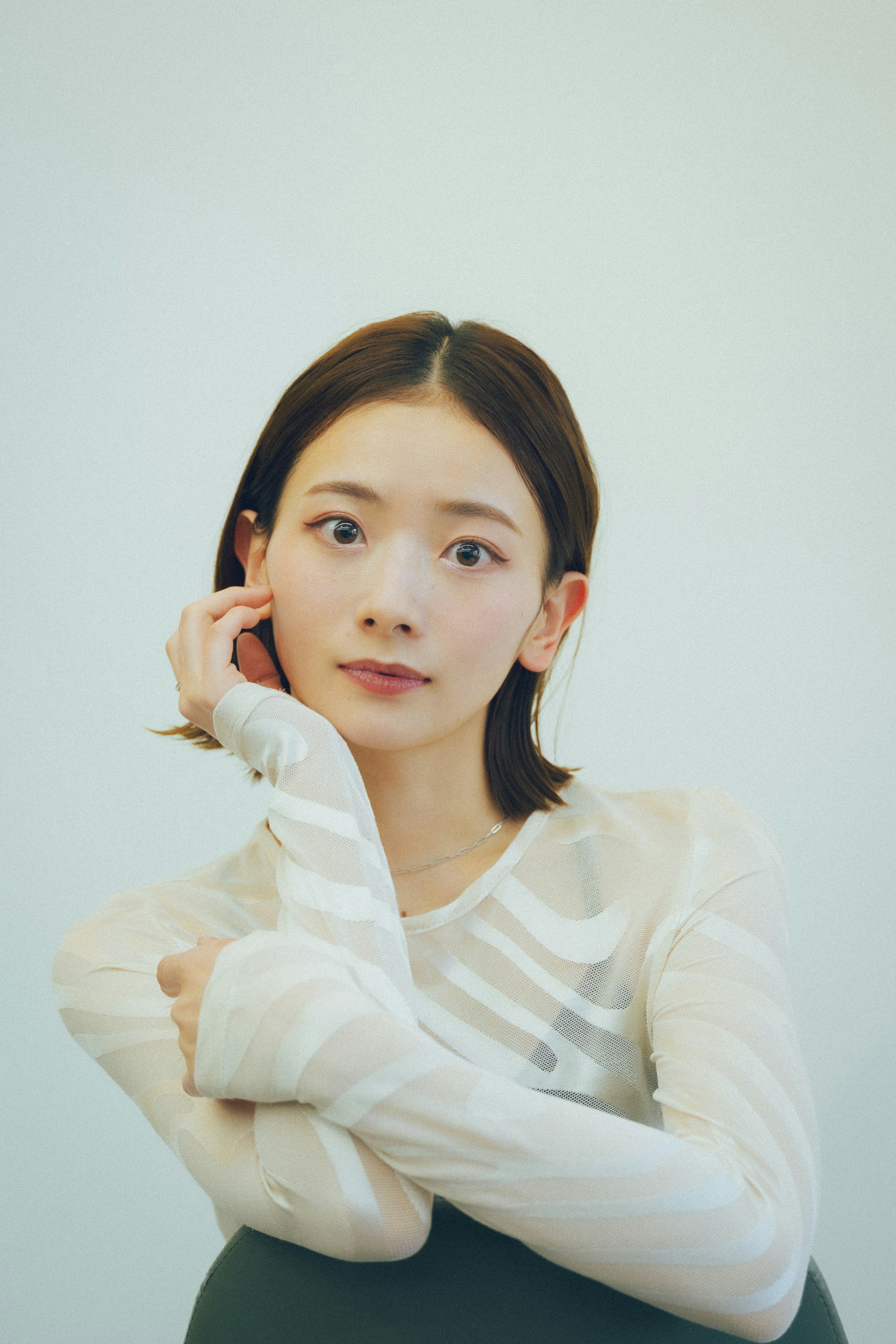 白色背景下双手靠近脸部的女性肖像