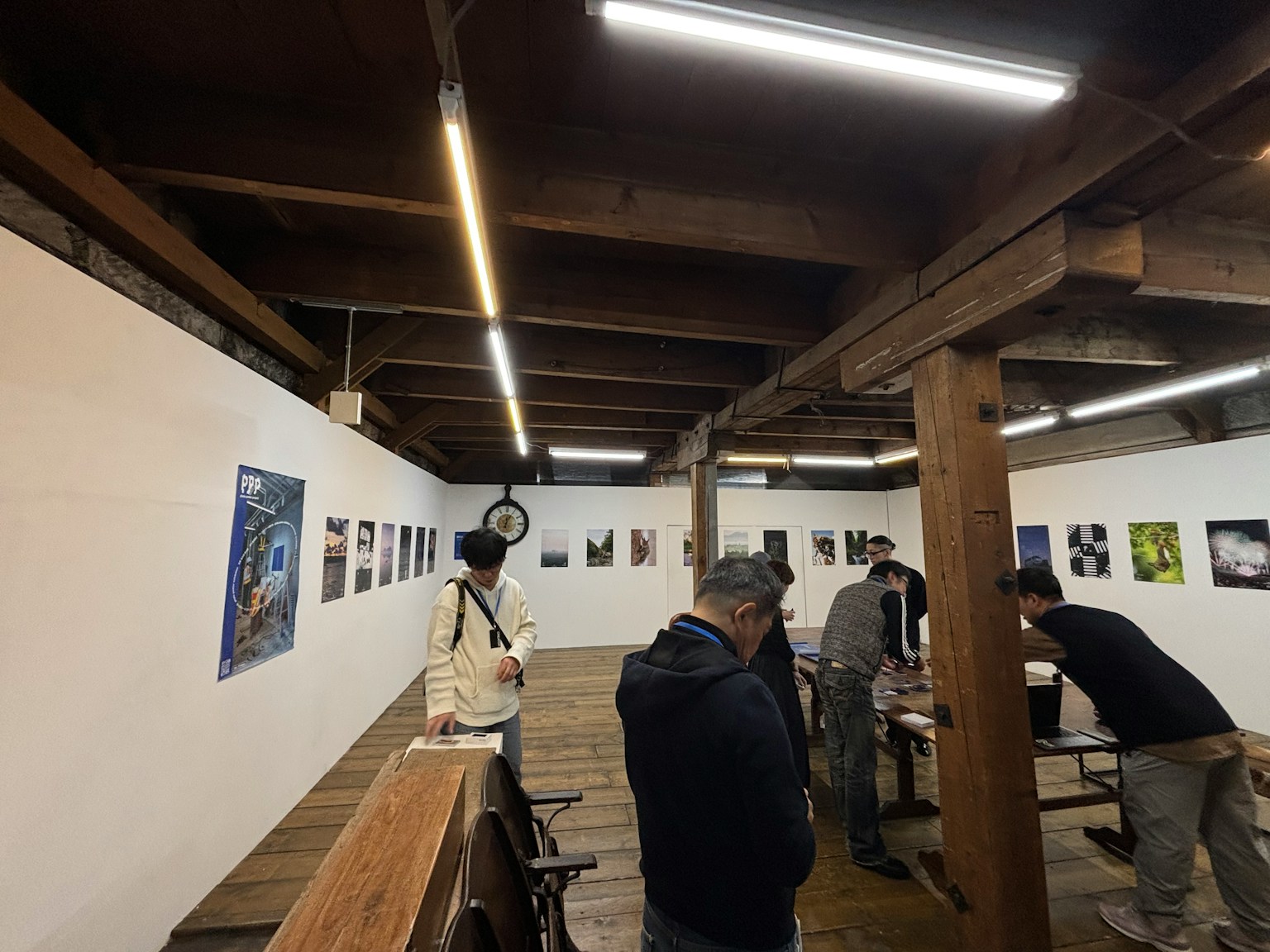 艺术画廊内部，木梁和明亮的照明，展示人们欣赏艺术作品