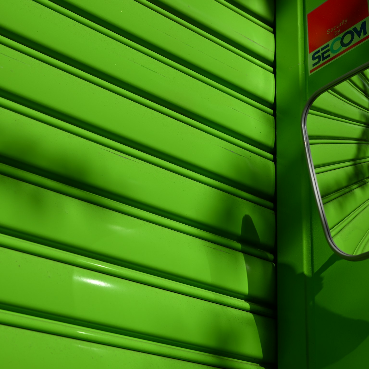 Volet vert vif avec un miroir réfléchissant dans un cadre urbain