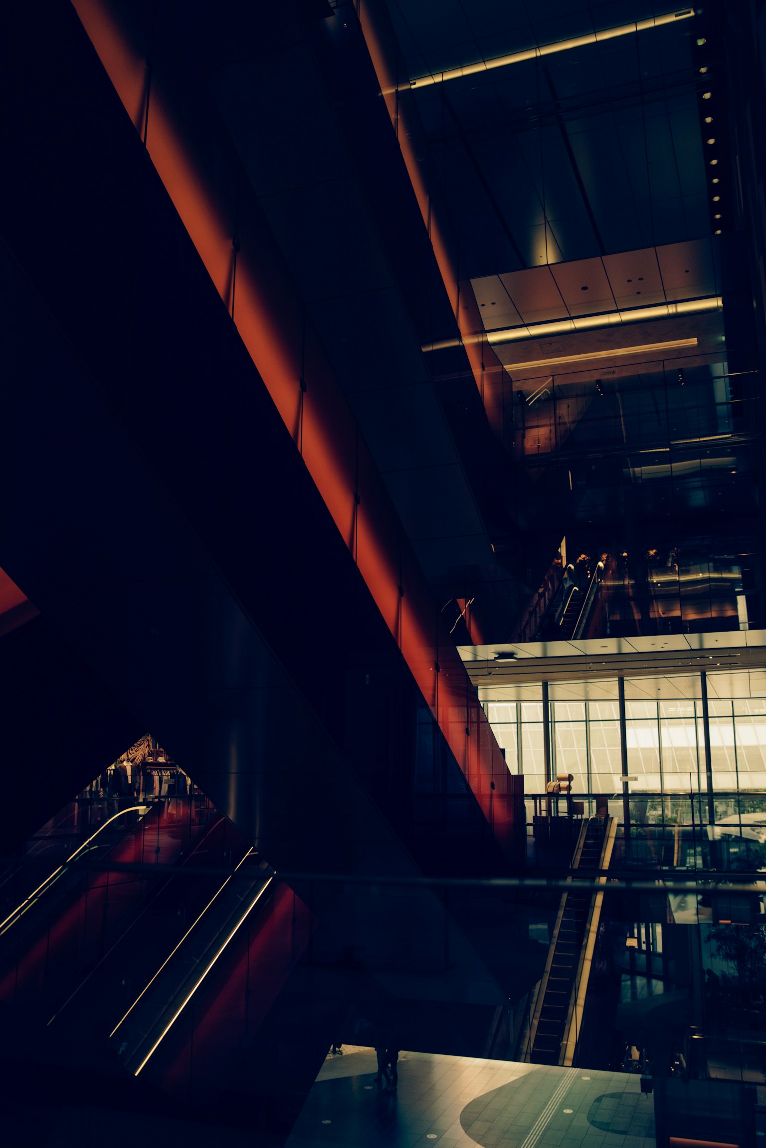View from a high floor of a modern building showcasing illuminated stairs and glass walls