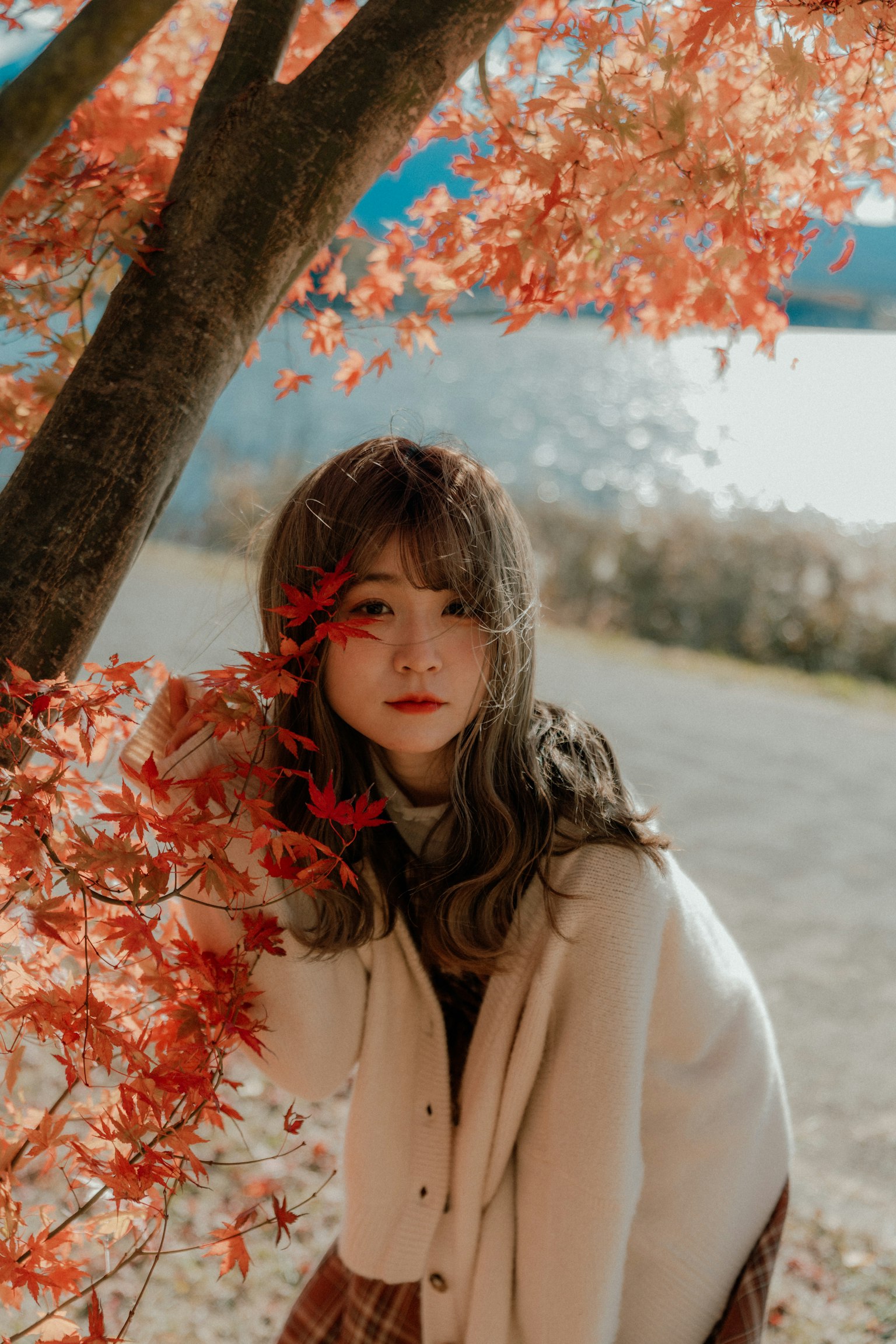 Portrait of a woman posing amidst autumn leaves