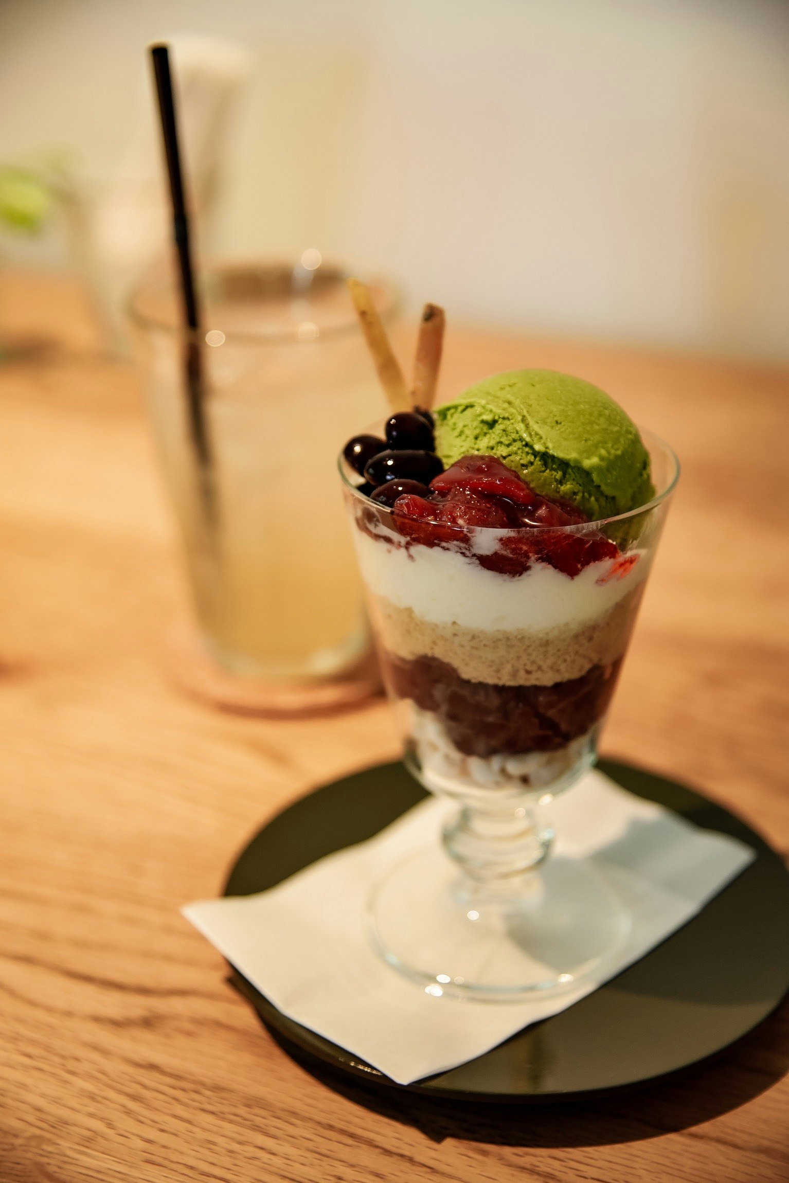 Dessert parfait topped with green tea ice cream and fruits
