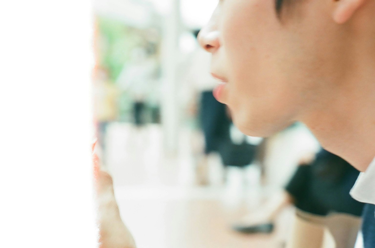 A man reaching out towards something with blurred people in the background