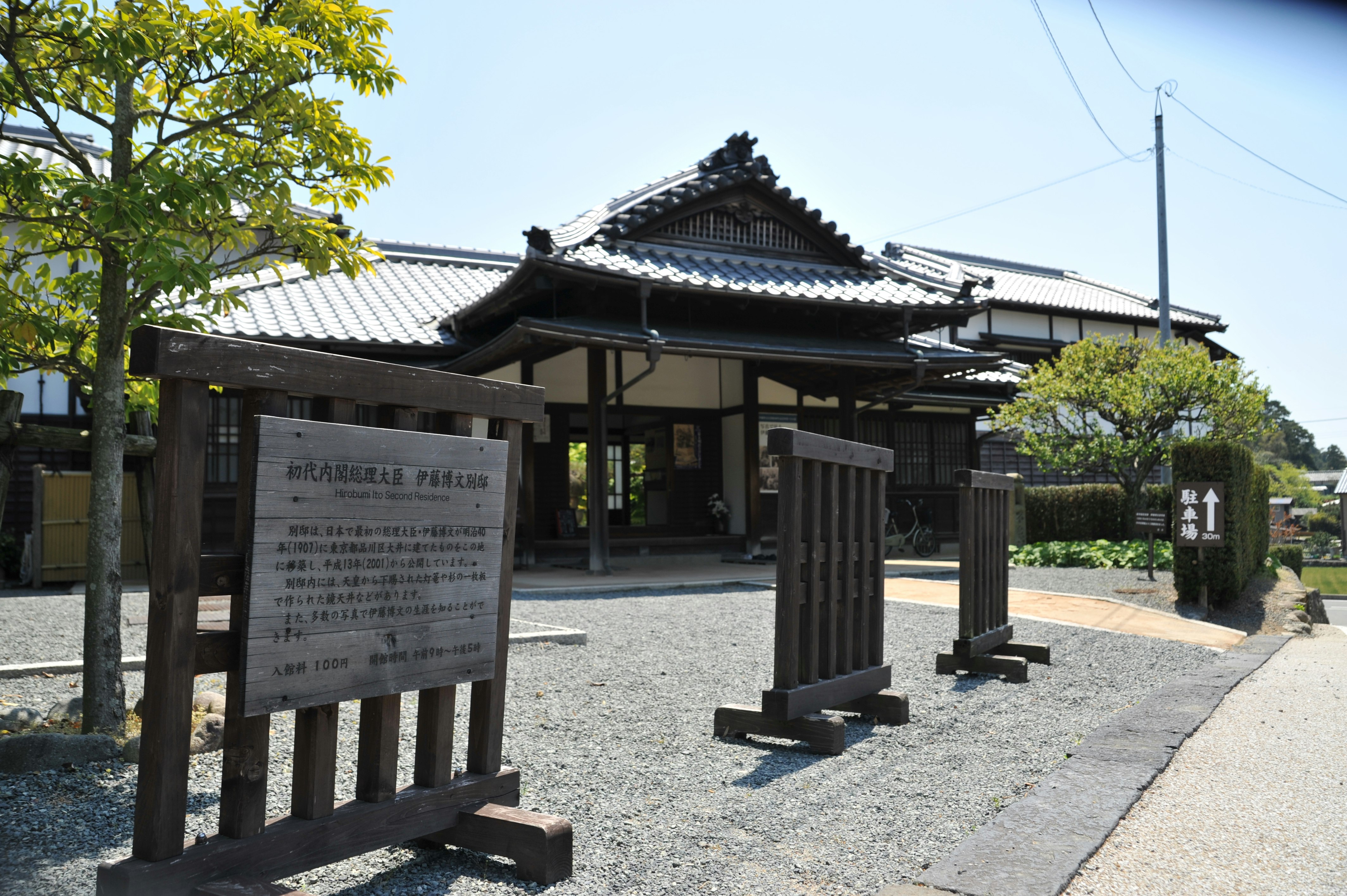 Entrée de jardin japonais avec clôture en bois et panneaux d’information