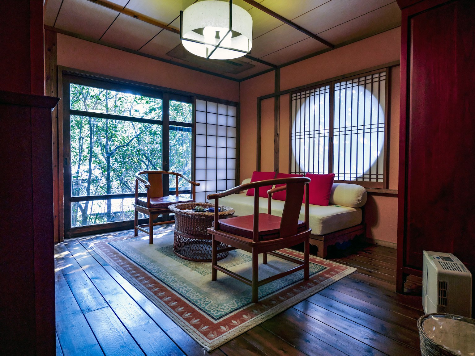Japanisch gestaltetes Wohnzimmer mit Holzmöbeln und großen Fenstern