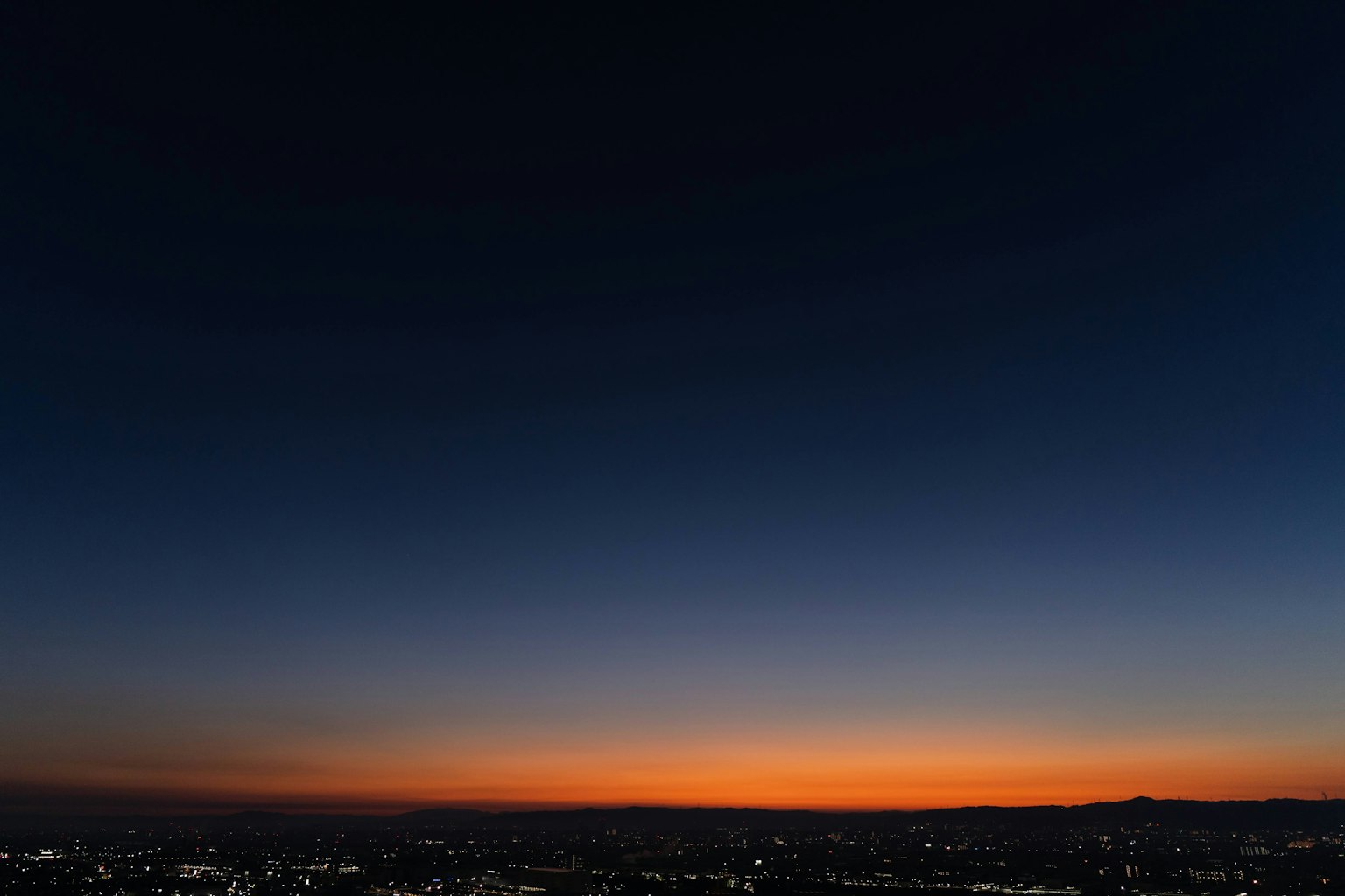 Hermoso degradado del amanecer con luces de la ciudad visibles