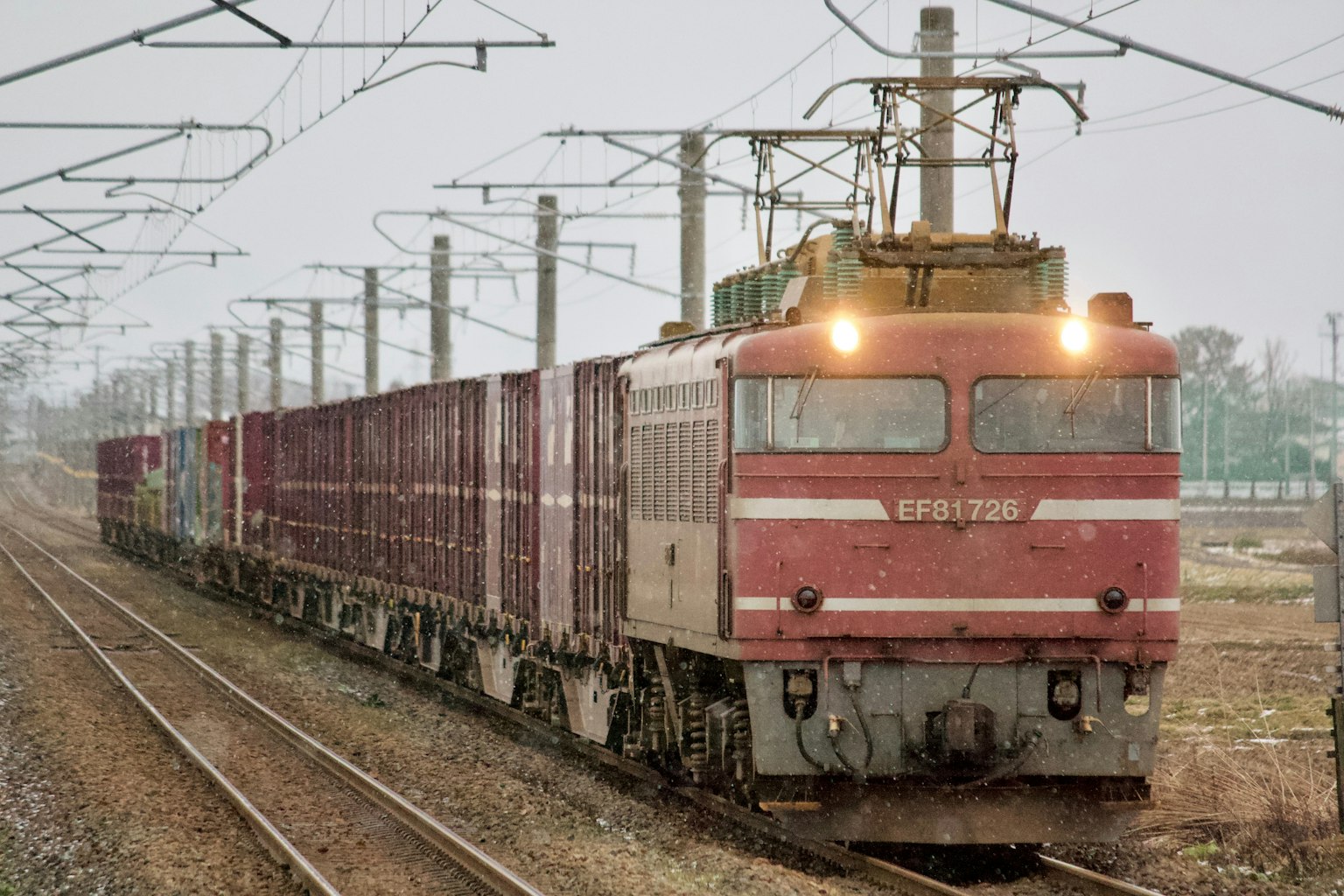 Red freight train traveling along the tracks